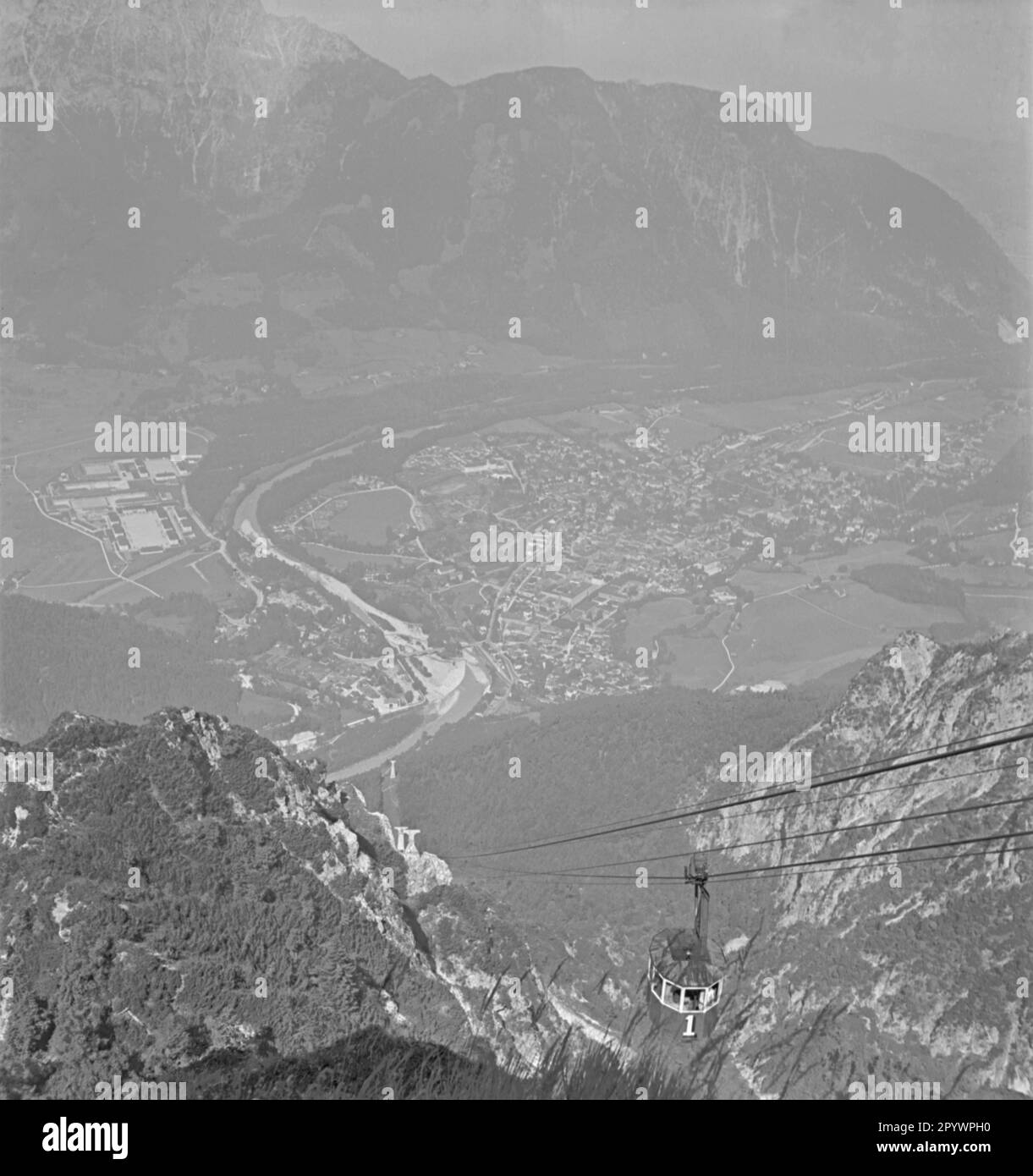 Eine Gondel hebt einen Berg im Salzkammergut hoch. Die Alpen und das Tal sind von oben zu sehen. Unbezahltes Foto von etwa 1935. Stockfoto