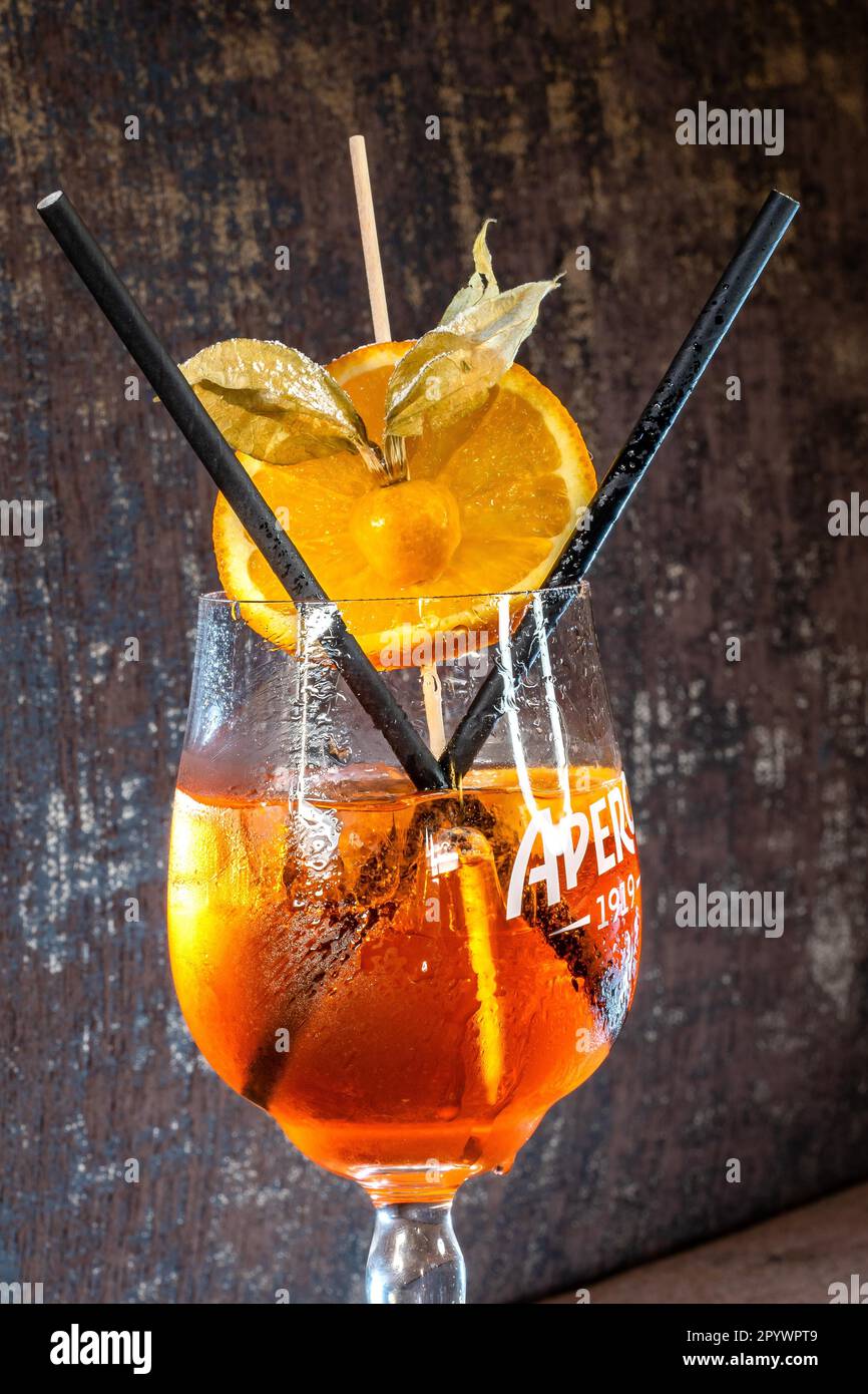 Cocktailglas mit Hugo-Getränk und zwei Strohhalmen mit braunem Hintergrund Stockfoto