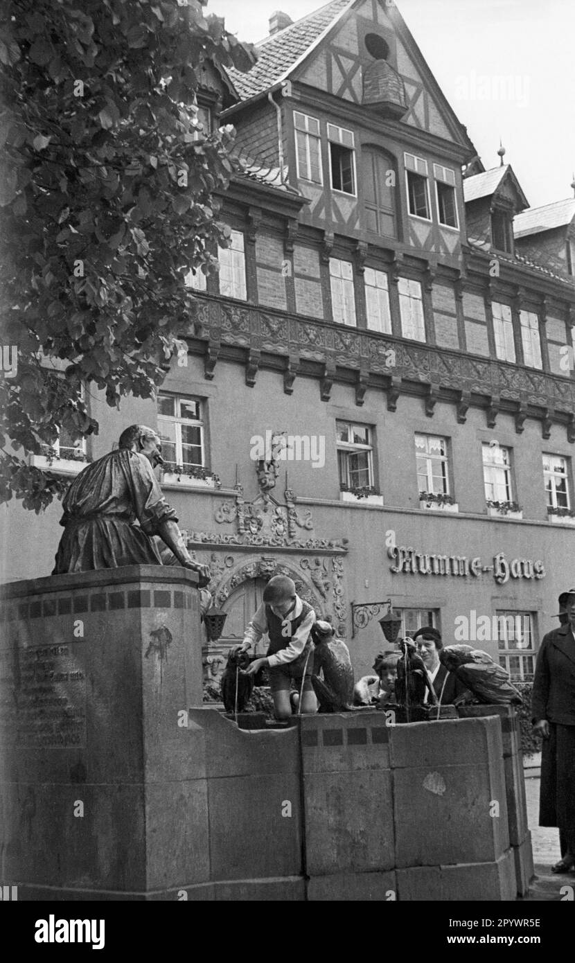 Der Eulenspiegelbrunnen im Zentrum von Brunswick zeigt einen Streich von Till Eulenspiegel, der Eulen und Guenons anstatt Brot und Brötchen in einer Bäckerei in Brunswick gebacken hat. Auf dem Brunnen liegt eine lebensgroße Bronzefigur von Till Eulenspiegel, zu seinen Füßen zwei Eulen und drei Affen, ebenfalls aus Bronze. Stockfoto