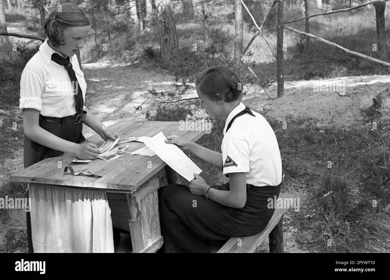 Zwei Briefleserinnen im Sommercamp des Bund Deutscher Maedel in Karlshagen. Unbezahltes Foto von etwa 1937 Stockfoto