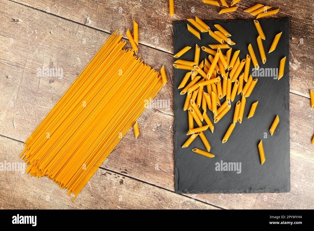 Trocknen Sie ungekochte Pasta auf einem Holzküchentisch Stockfoto