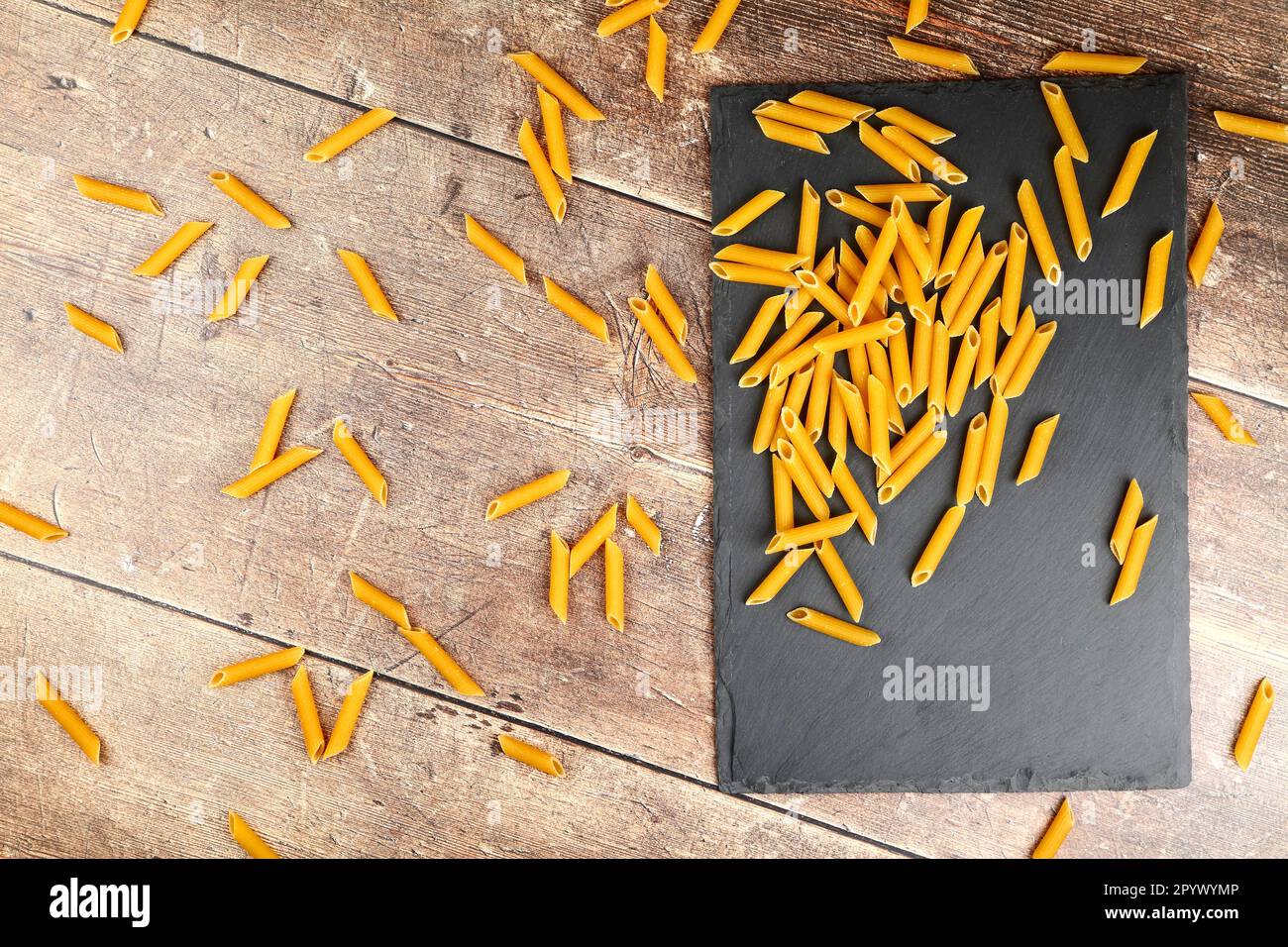 Trocknen Sie ungekochte Pasta auf einem Holzküchentisch Stockfoto