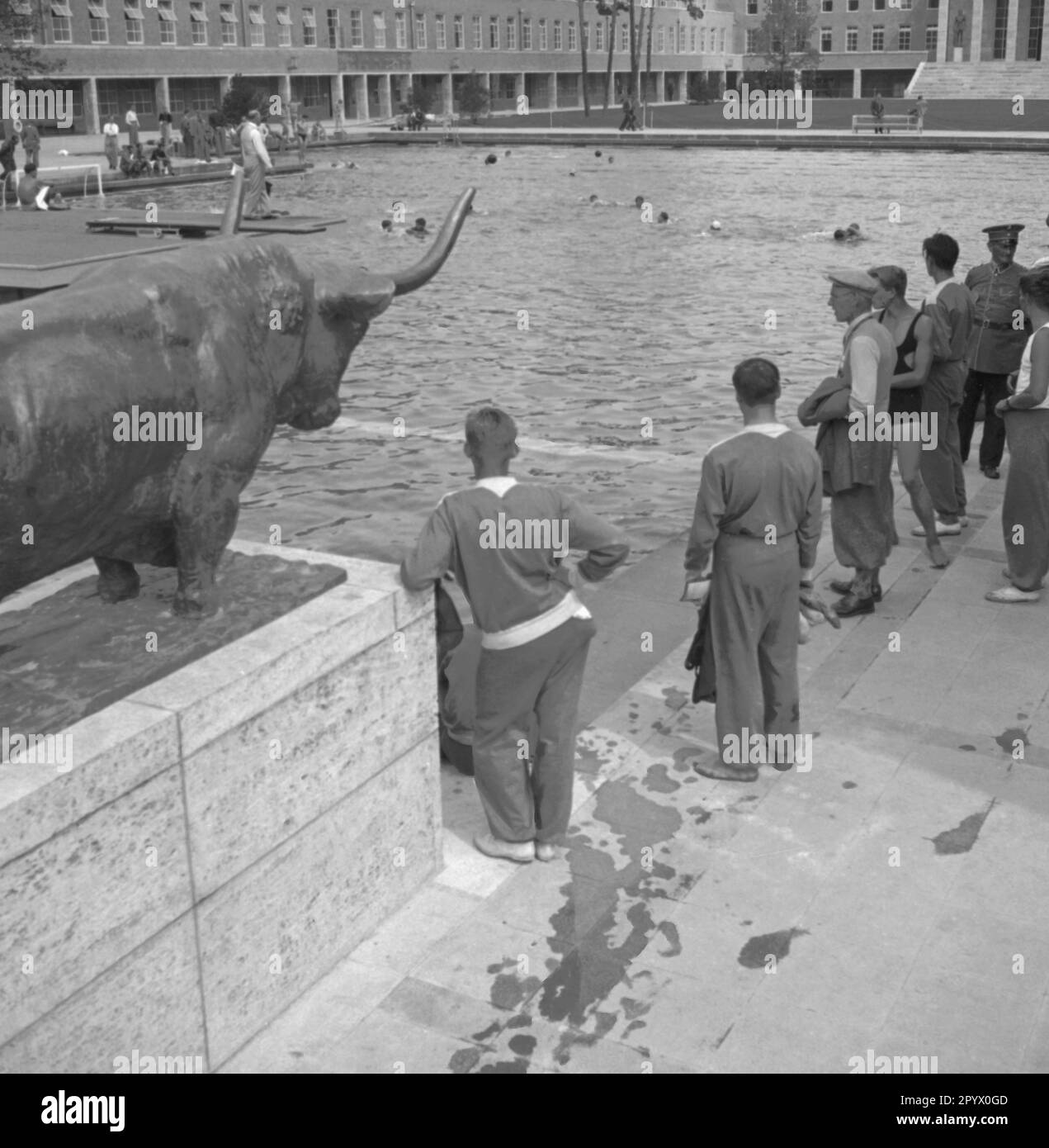 Sportler während der Olympischen Sommerspiele auf dem Deutschen Olympischen Sportforum im Olympiapark. Das Bild zeigt die Skulptur Stier und Kuh von Adolf Struebe. Stockfoto