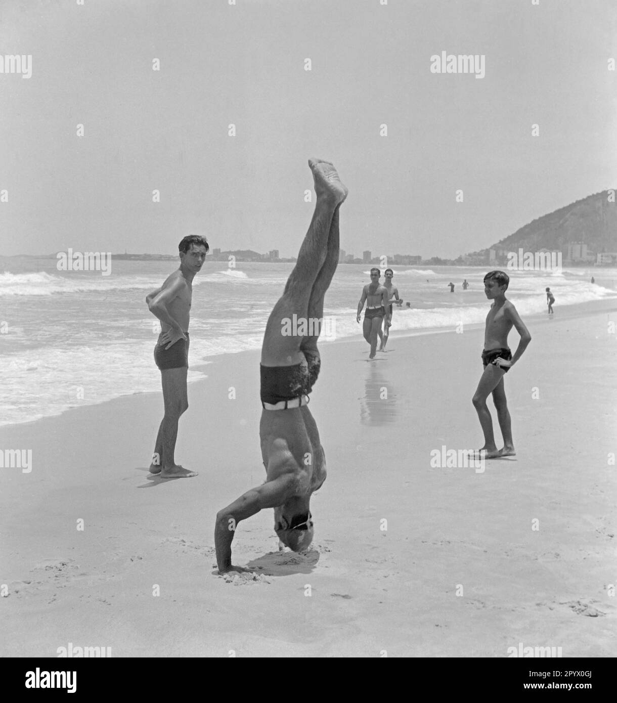 Ein brasilianischer Mann während seiner akrobatischen Darbietung am Strand. Stockfoto