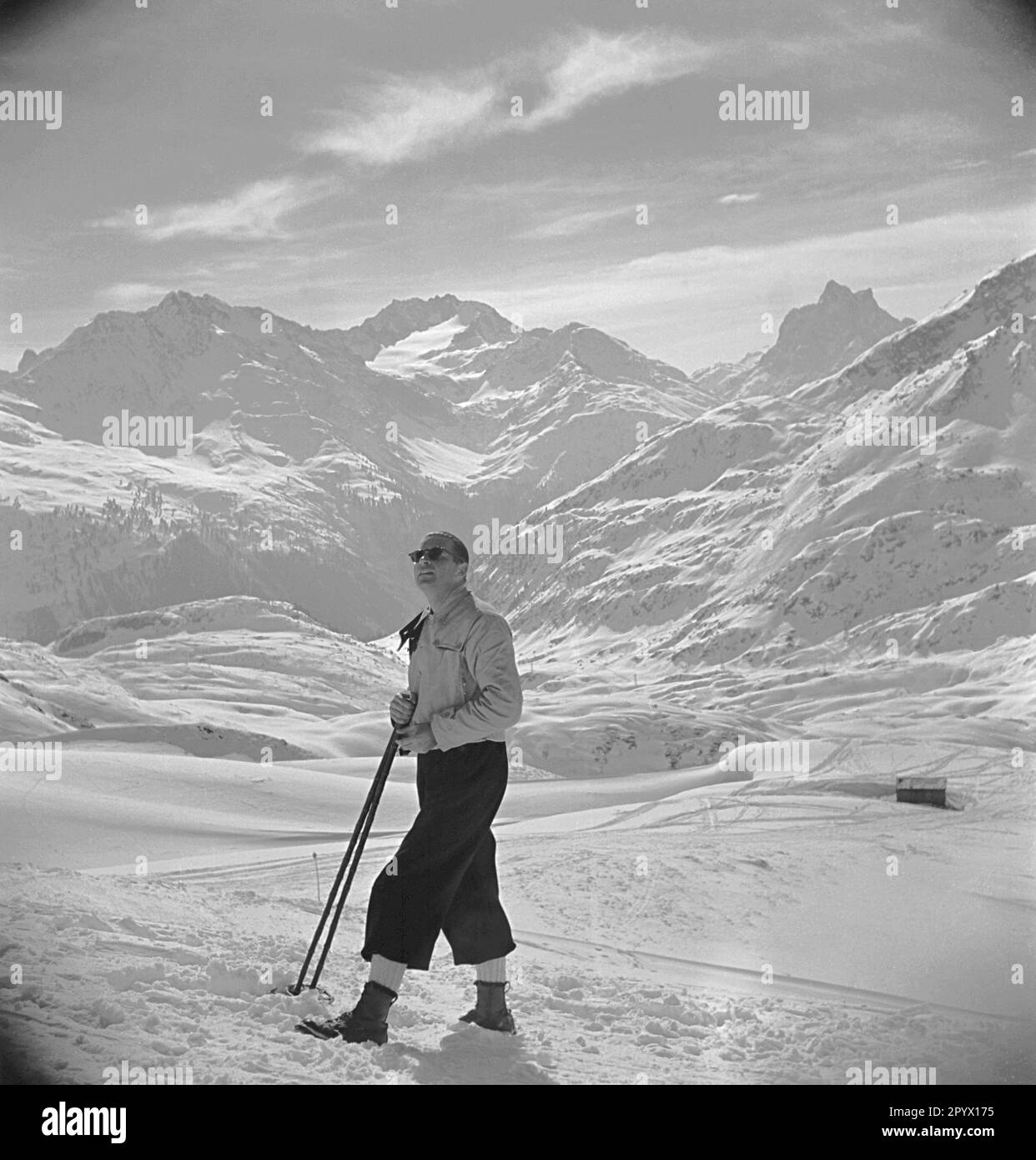 Skitourer mit Stöcken im Schnee, Mitte 1930er. Stockfoto