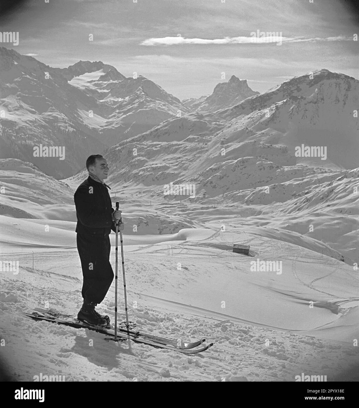 Ein Tourist vor einer Bergkulisse im Skigebiet Arlberg Mitte der 1930er Jahre. Stockfoto