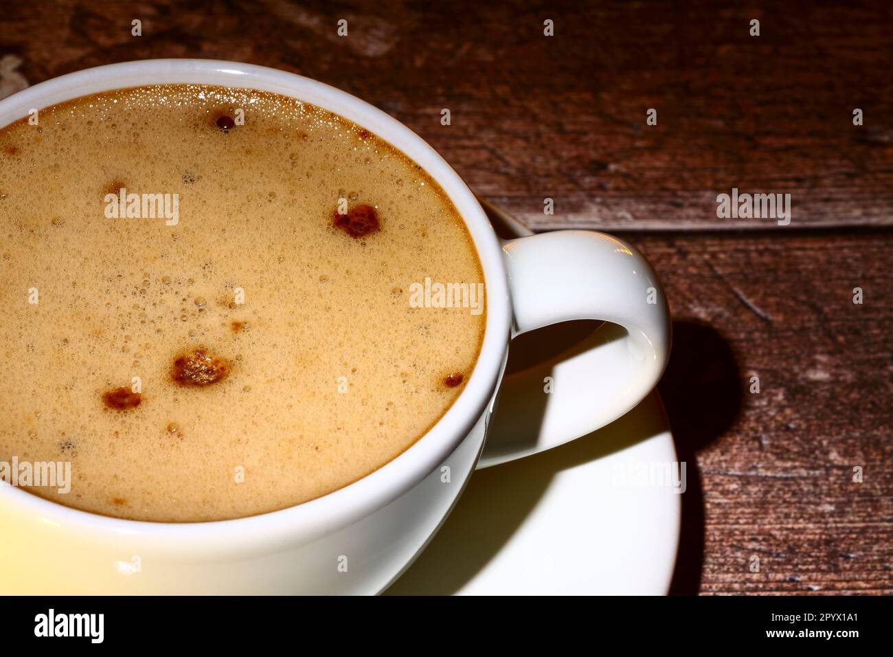 Nahaufnahme einer weißen Kaffeetasse auf einem Holztisch Stockfoto