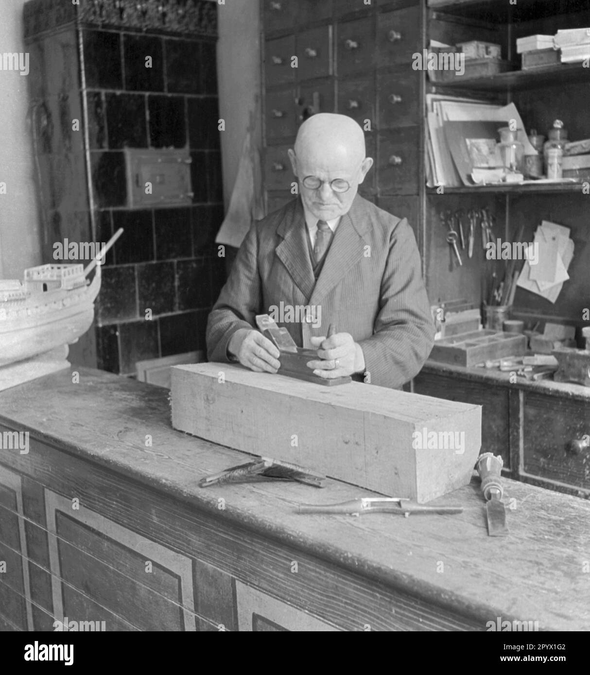 Der Modellbauer Robert Daehncke, der an einem seiner Schiffsmodelle arbeitet. Stockfoto