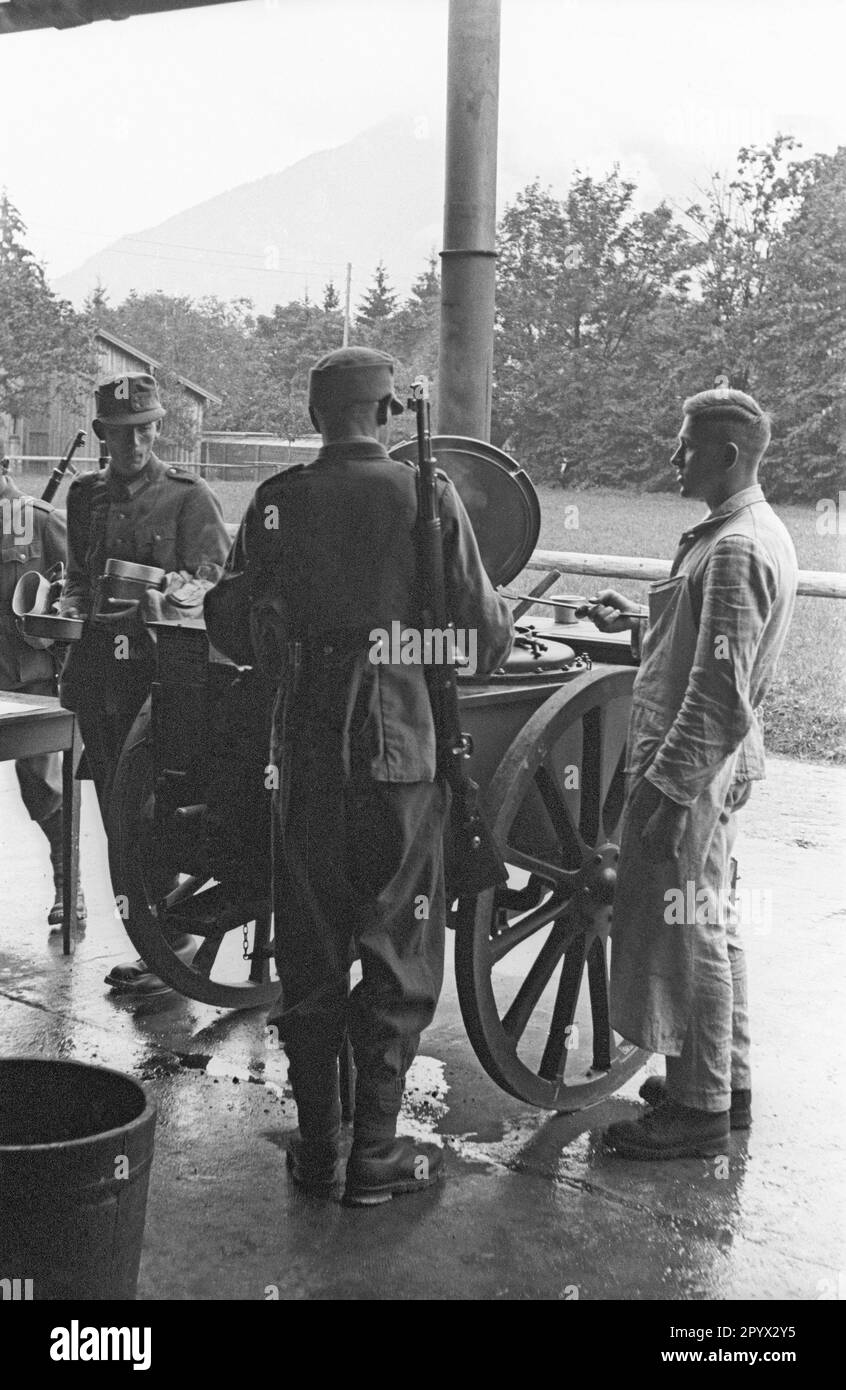 Während einer Übung einer Gebirgsjaegerkompanie (Mountain Infanterie Company) auf dem Tegernsee erhalten Soldaten mit Kochgeschirr Essen in der Feldküche. Stockfoto