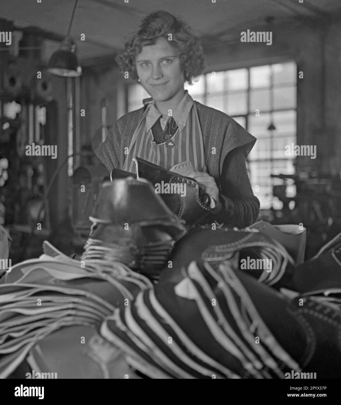 In einem Workshop des Kinderhilfswerks der Vereinten Nationen in Berlin arbeitet eine Frau an der Herstellung von Schuhen. Stockfoto