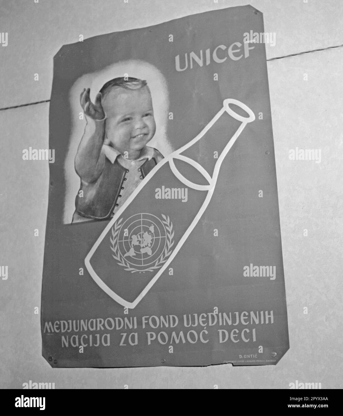 Poster für das Kinderhilfswerk der Vereinten Nationen (UNICEF) auf Serbokroatisch aus Zagreb. Neben einem winkenden Kind ist eine Milchflasche. Stockfoto