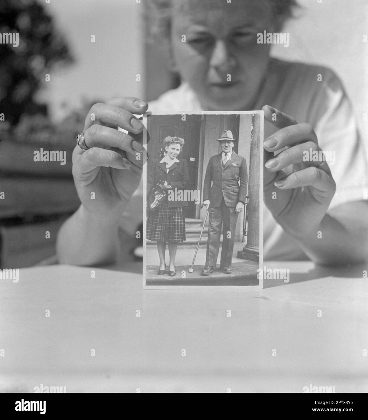 Eine Frau zeigt ein Foto des Chirurgen Ferdinand Sauerbruch zusammen mit einer jungen Frau (vermutlich selbst). Stockfoto