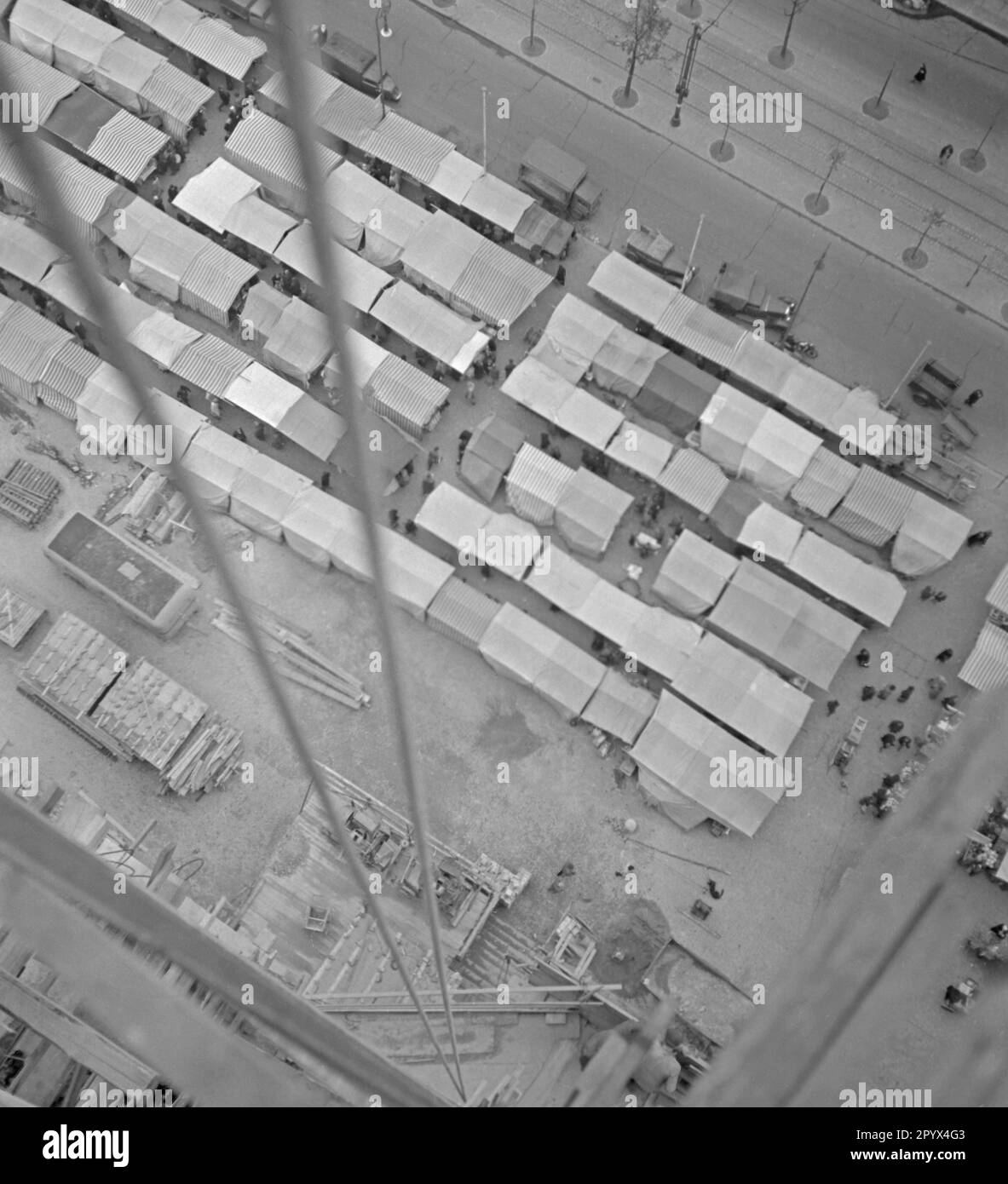 Blick auf den Gerüstturm des Rathaus Schoeneberg auf dem Wochenmarkt am Rathausplatz am 21. Oktober 1950. Am selben Tag wurde die Freiheitsglocke im Turm des Sitzes des Berliner Bürgermeisters Ernst Reuter (1948-1953) installiert. Die Glocke ertönte zum ersten Mal bei der Zeremonie am Tag der Vereinten Nationen (UNO) am 24. Oktober. Stockfoto