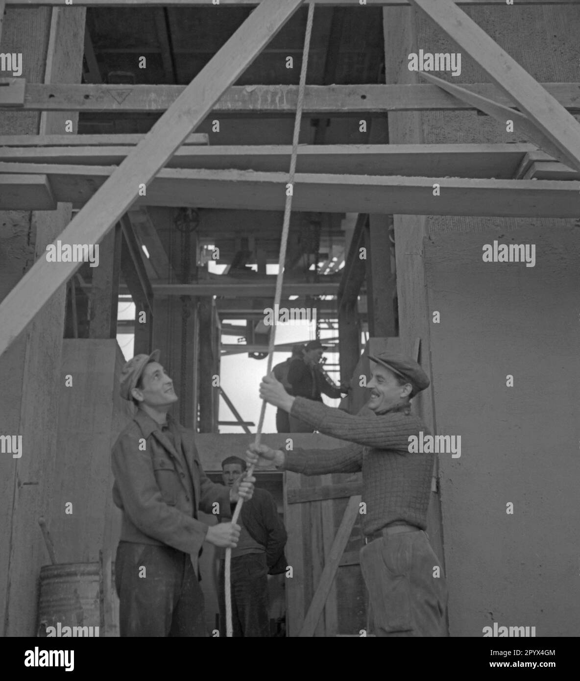 Foto von zwei Bauarbeitern auf dem Turmgerüst des Rathaus Schoeneberg in Westberlin am 21. Oktober 1950. Das Foto wurde am Tag der Installation der Freiheitsglocke im Turm des Sitzes des Berliner Bürgermeisters Ernst Reuter (1948-1953) aufgenommen. Die Glocke ertönte zum ersten Mal bei der Zeremonie des UNO-Tages am 24. Oktober. Stockfoto