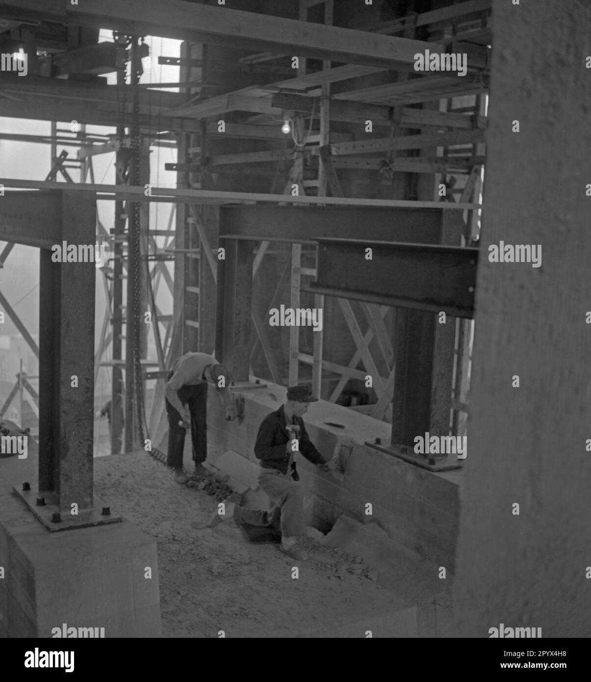 Foto von zwei Bauarbeitern auf dem Turmgerüst des Rathaus Schoeneberg in Westberlin am 21. Oktober 1950. Das Foto wurde am Tag der Installation der Freiheitsglocke im Turm des Sitzes des Berliner Bürgermeisters Ernst Reuter (1948-1953) aufgenommen. Die Bauarbeiter arbeiten an den letzten Vorbereitungen für die Installation der Glocke. Die Glocke ertönte zum ersten Mal bei der Zeremonie am Tag der Vereinten Nationen (UNO) am 24. Oktober. Stockfoto