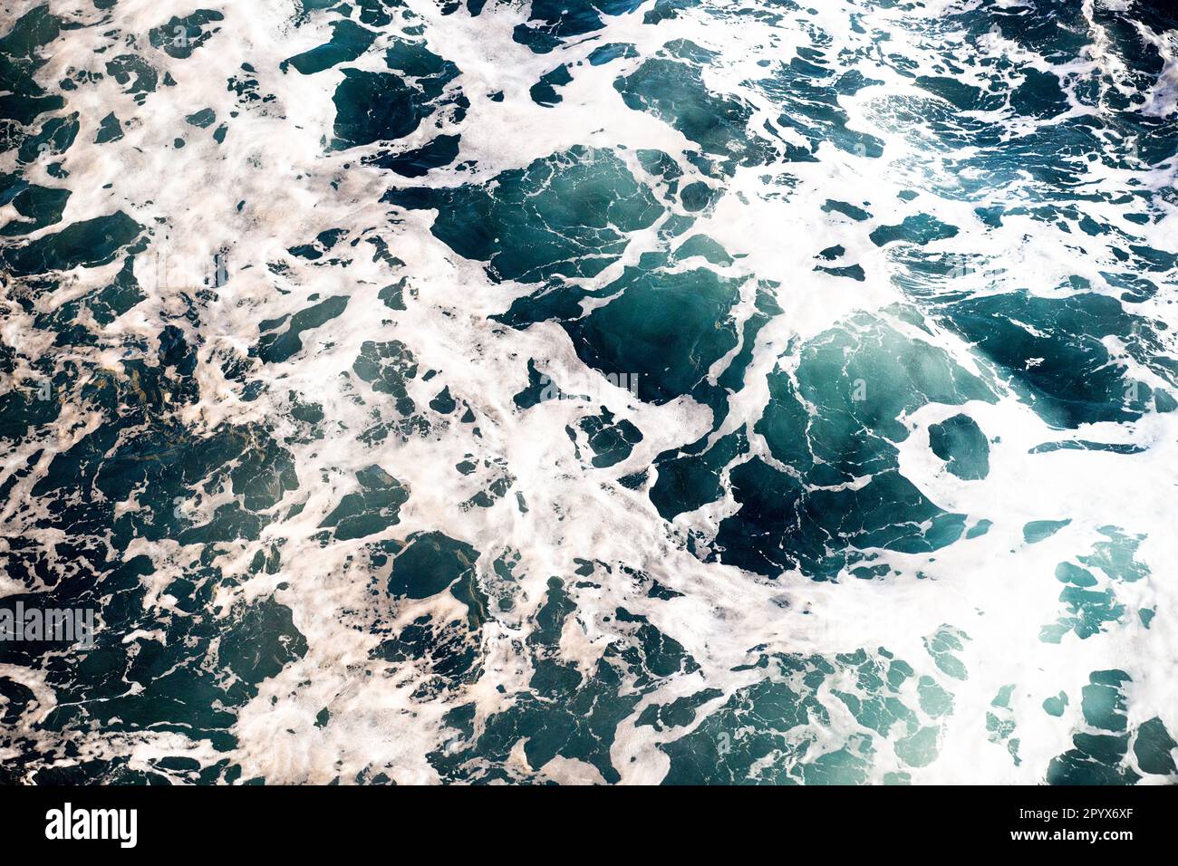Blaue Wellen, weißer Meeresschaum-Hintergrund Stockfoto