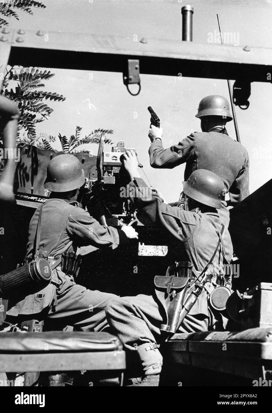 Die Wehrmacht hat während einer Demonstration, wahrscheinlich auf einem militärischen Trainingsgelände in Deutschland, Panzertransporter gepanzert. Der gepanzerte Personentransporter ist mit einem 3,7cm Pak ausgestattet. Der Kommandant feuert ein Leuchtsignal ab. Foto: Schwahn Stockfoto