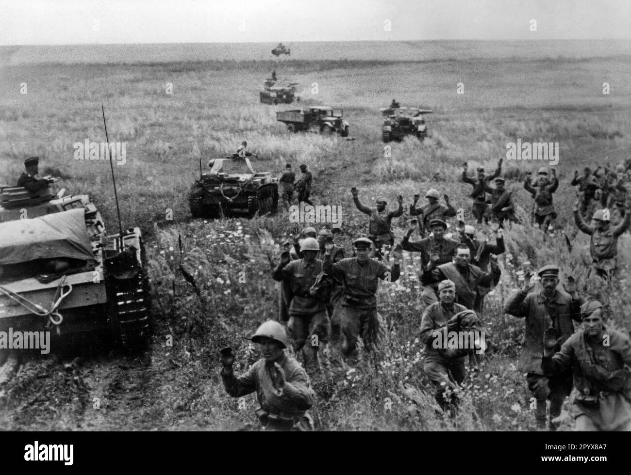 Russische Soldaten ergeben sich und gehen an einer deutschen Panzereinheit vorbei in Gefangenschaft. Vor einem Panzer III, im Hintergrund einem Panzer IV Das Foto wurde während der deutschen Offensive in der Südukraine in Richtung Stalingrad aufgenommen. [Maschinelle Übersetzung] Stockfoto