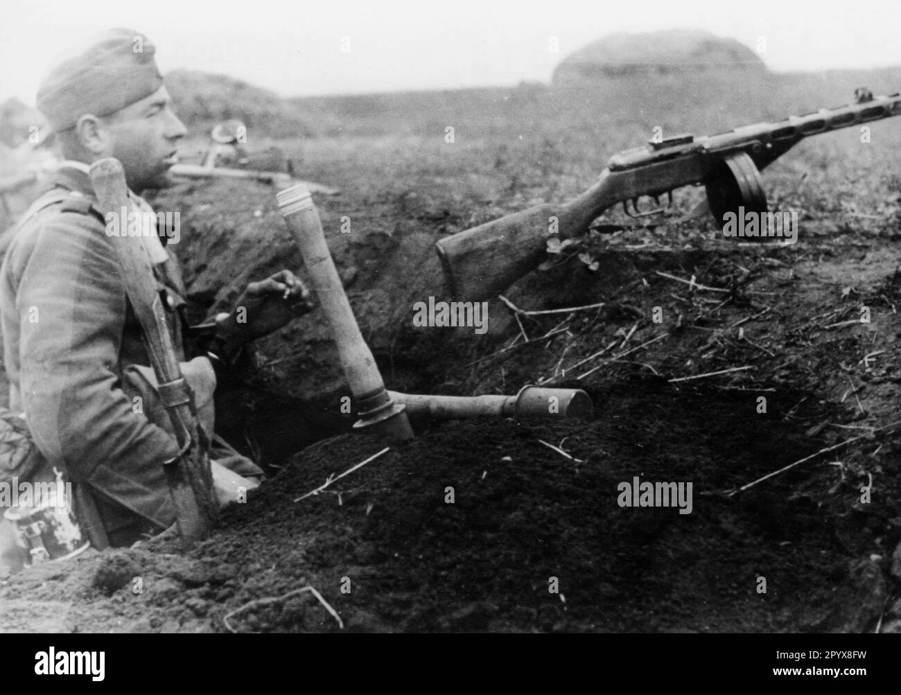 Ein deutscher Infanterist in der Nähe von Poltava im südlichen Teil der Ostfront. Auf dem Grabenhang vor ihm befindet sich eine russische geplünderte Waffe, eine PPSch-41 (Schpagin)-Submaschinenwaffe. Foto: Rebhan. [Maschinelle Übersetzung] Stockfoto