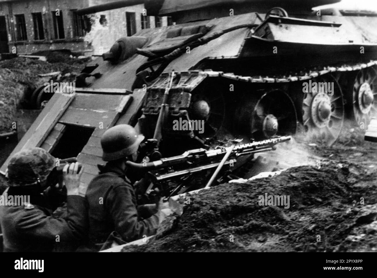 Deutsche Soldaten mit Maschinengewehr MG 34 in Stellung in Voronezh. Sie errichteten einen Unterschlupf unter der heruntergekommenen T34. Foto: Müller-Schwannecke [maschinelle Übersetzung] Stockfoto