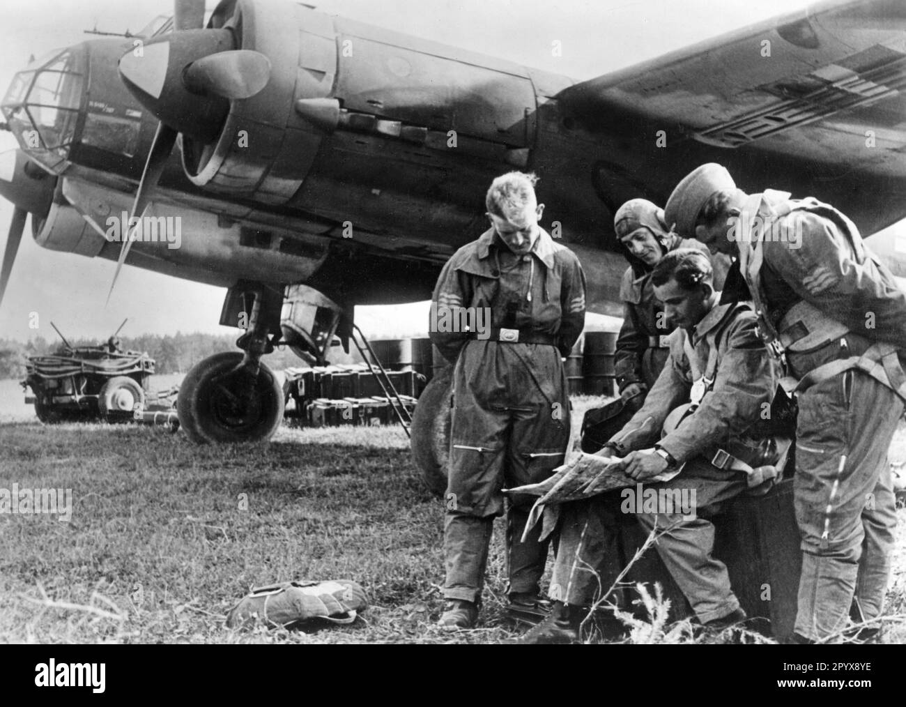 Crew eines Junkers 88 Bombers auf einem lettischen Flugplatz bei der Besprechung. Die Tauchbremse ist unter dem Flügel deutlich sichtbar. Foto: Brieke [automatisierte Übersetzung] Stockfoto