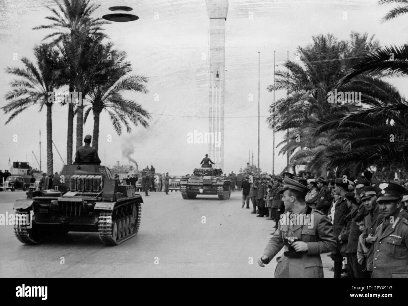 Eine Kolonne von Panzerkampfwagen II und III des deutschen Afrika Korps fährt während einer Parade durch Tripolis. Italienische Soldaten sind im Vordergrund zu sehen. Foto: Borchert [maschinelle Übersetzung] Stockfoto