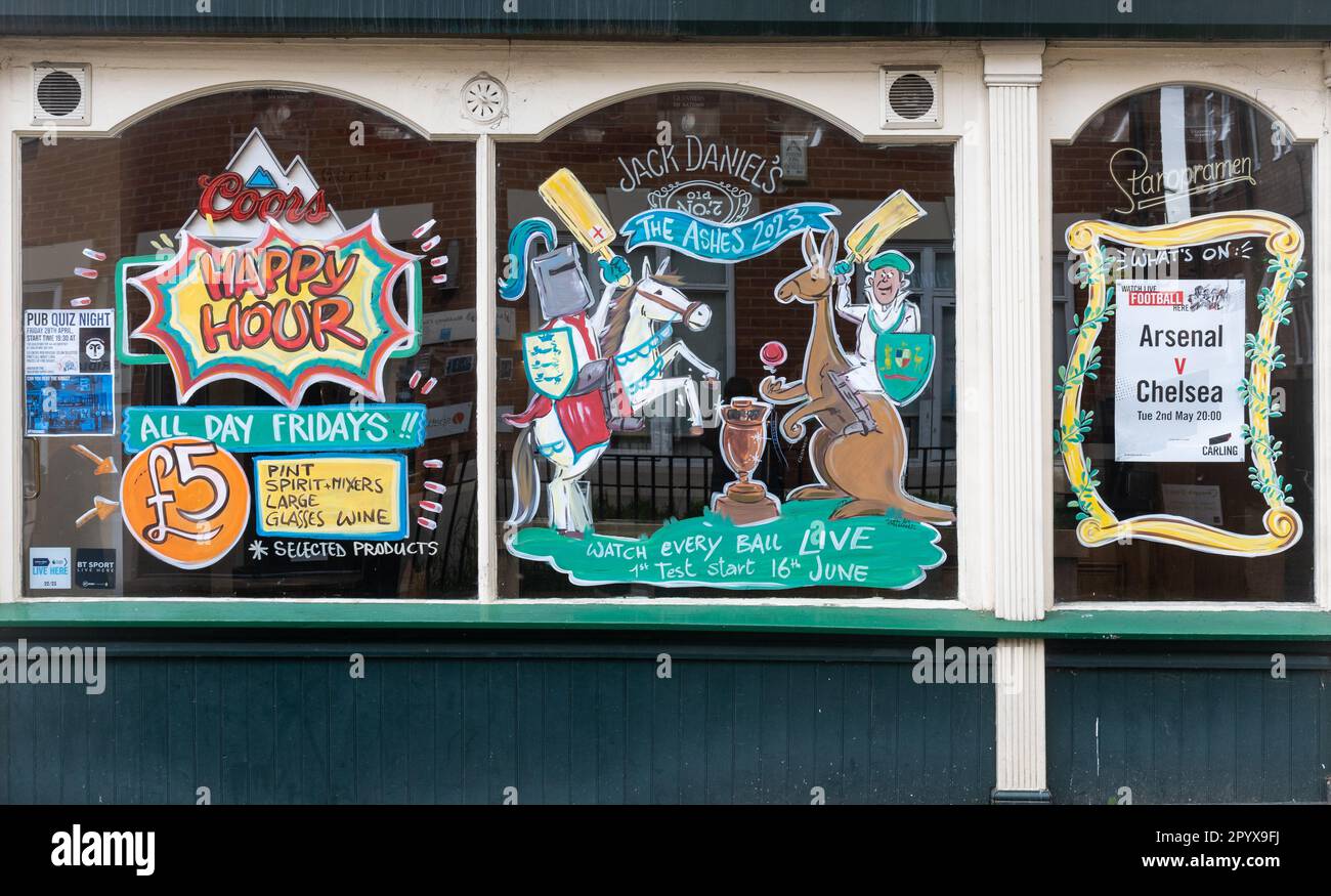 Geschmücktes Kneipenfenster mit Happy Hour und Sportveranstaltungen wie The Ashes und Fußball im Fernsehen, England, Großbritannien Stockfoto