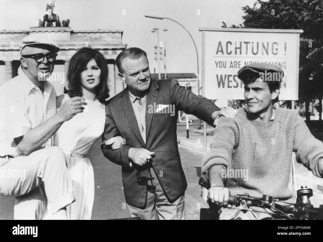 Amerikanischer Regisseur Billy Wilder, Schauspielerin Pamela Tiffin und Schauspieler James Cagney und Horst Buchholz (von links) vor dem Brandenburger Tor in Berlin während der Dreharbeiten des Films eins, zwei, drei. [Maschinelle Übersetzung] Stockfoto