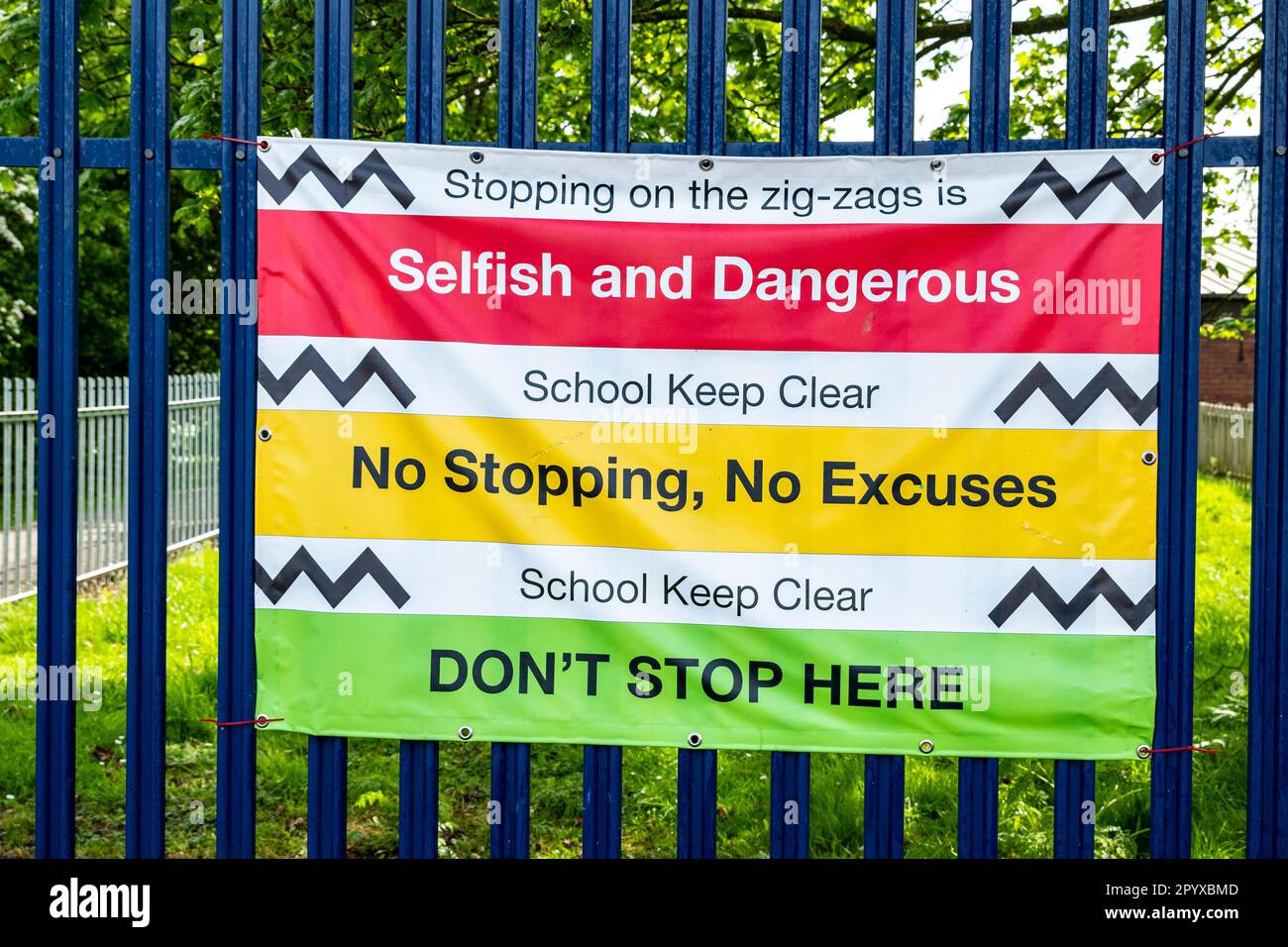 Ein Schulwarnbanner, auf dem steht, auf den Zickzacklinien anzuhalten, ist egoistisch und gefährlich in Crewe Cheshire UK Stockfoto