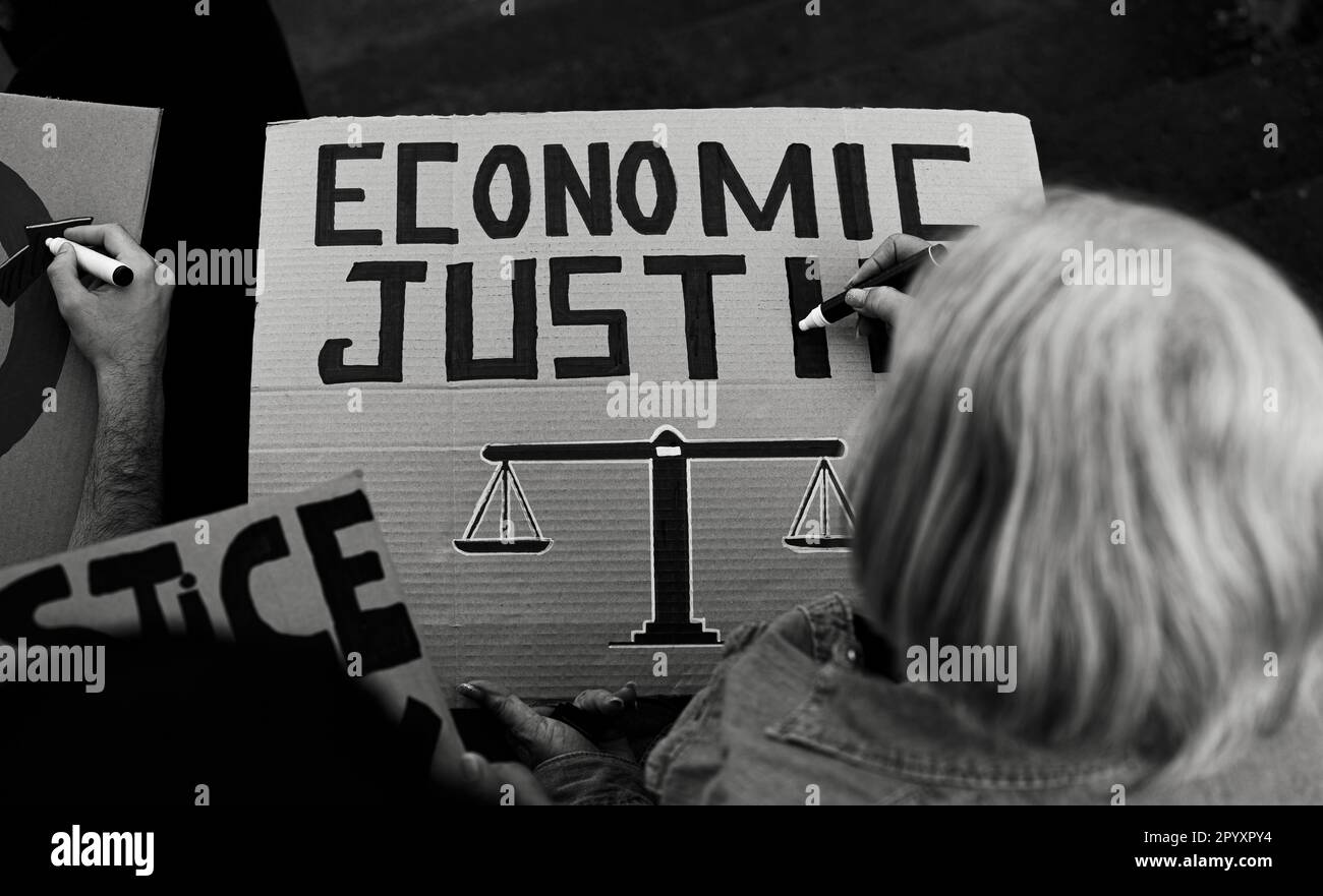 Hochrangiger Aktivist, der Protestbanner gegen die Finanzkrise vorbereitet - Aktivismuskonzept Wirtschaftsgerechtigkeit - Schwarzweiß-Editierung Stockfoto