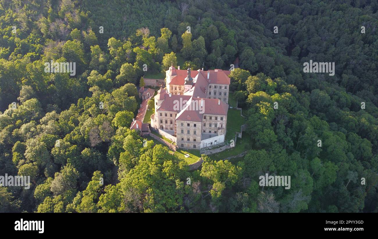 Ein Blick aus der Vogelperspektive auf das majestätische Schloss Jezeri befindet sich auf einem Hügel, der von einem üppigen Wald von Bäumen umgeben ist Stockfoto
