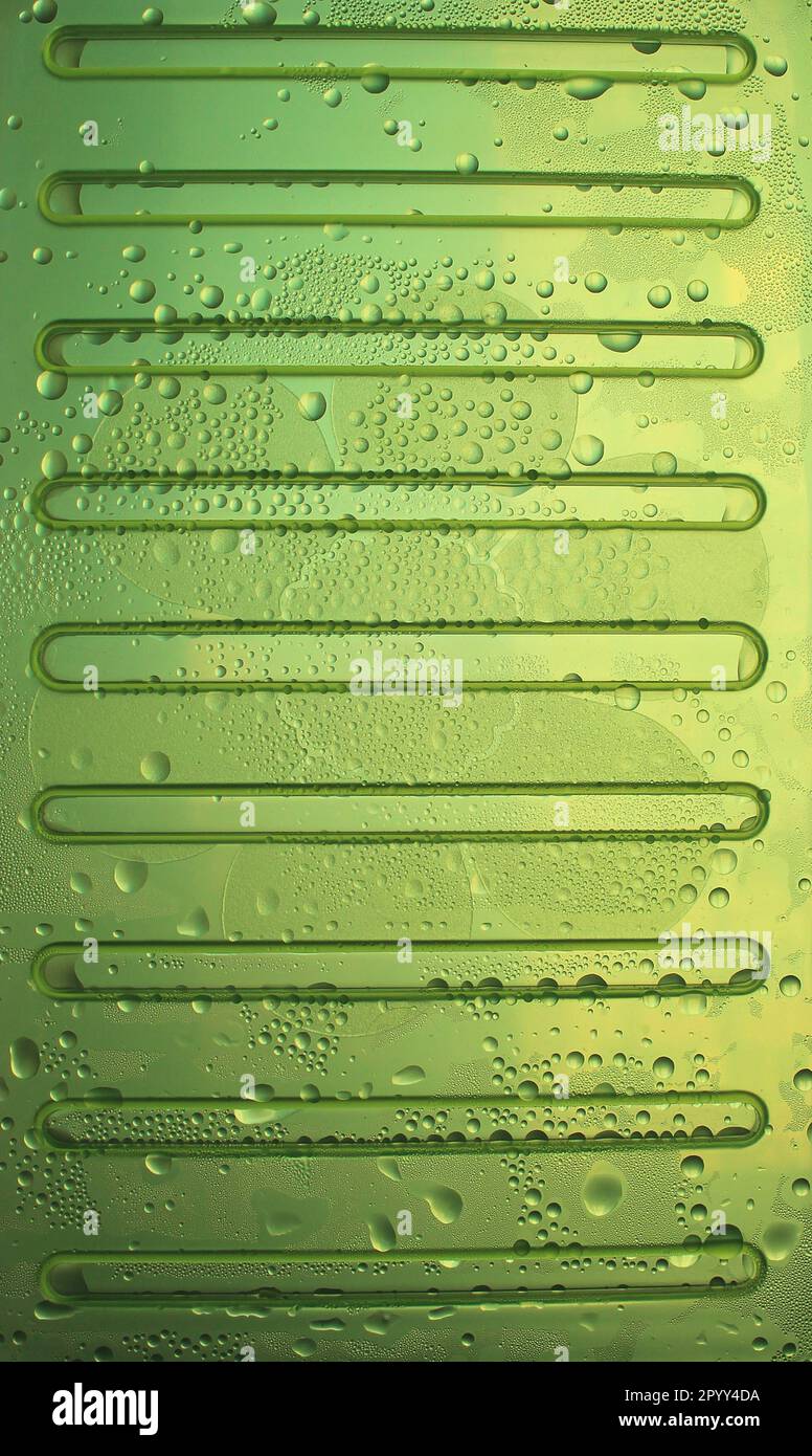 Tropfen kalten Wassers auf einem grünen, gewellten Flächenfoto für vertikalen Hintergrund Stockfoto