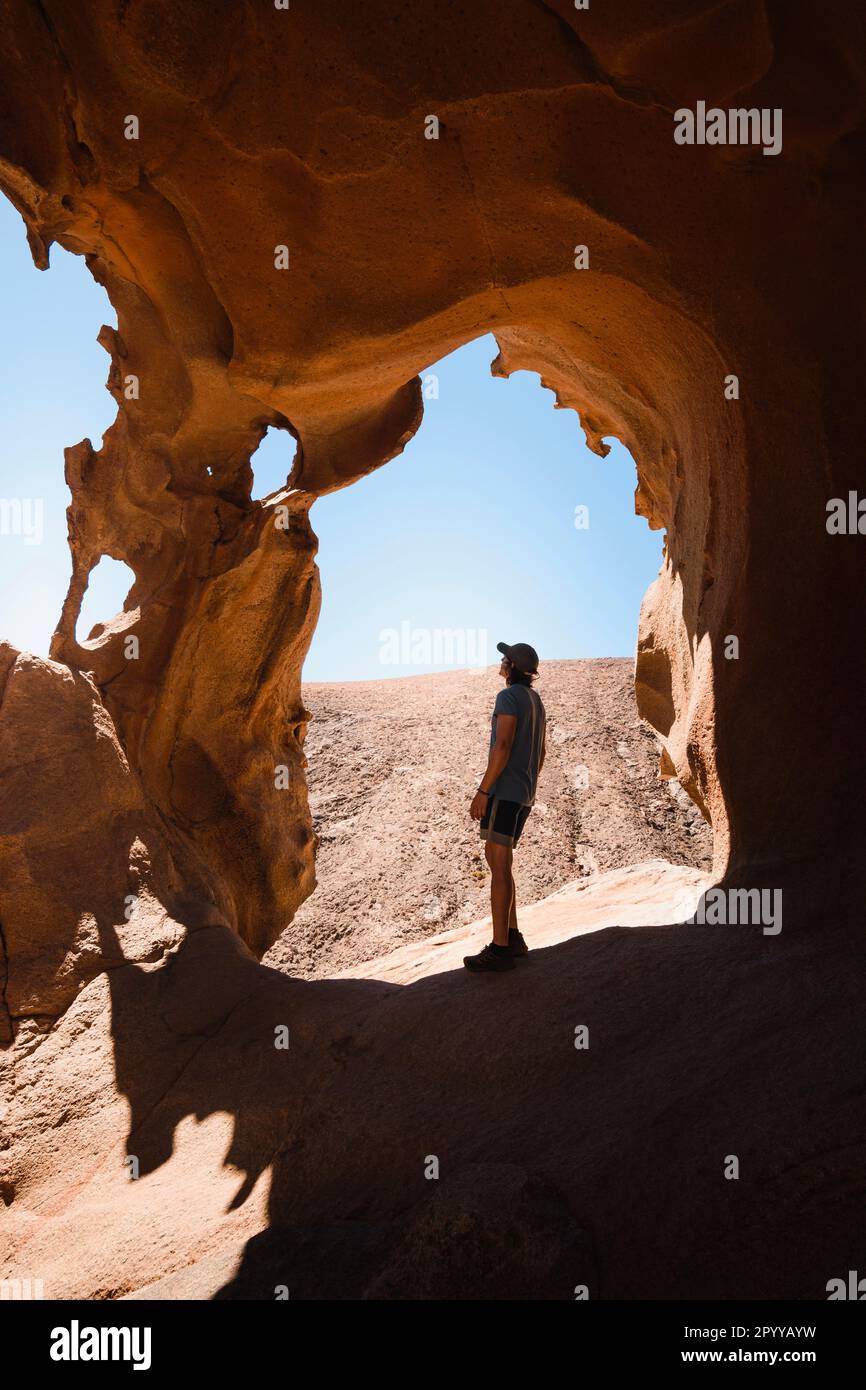 Ein Mann, der die Felsformationen des Las-Peñitas-Canyons in Fuerteventura beobachtet Stockfoto