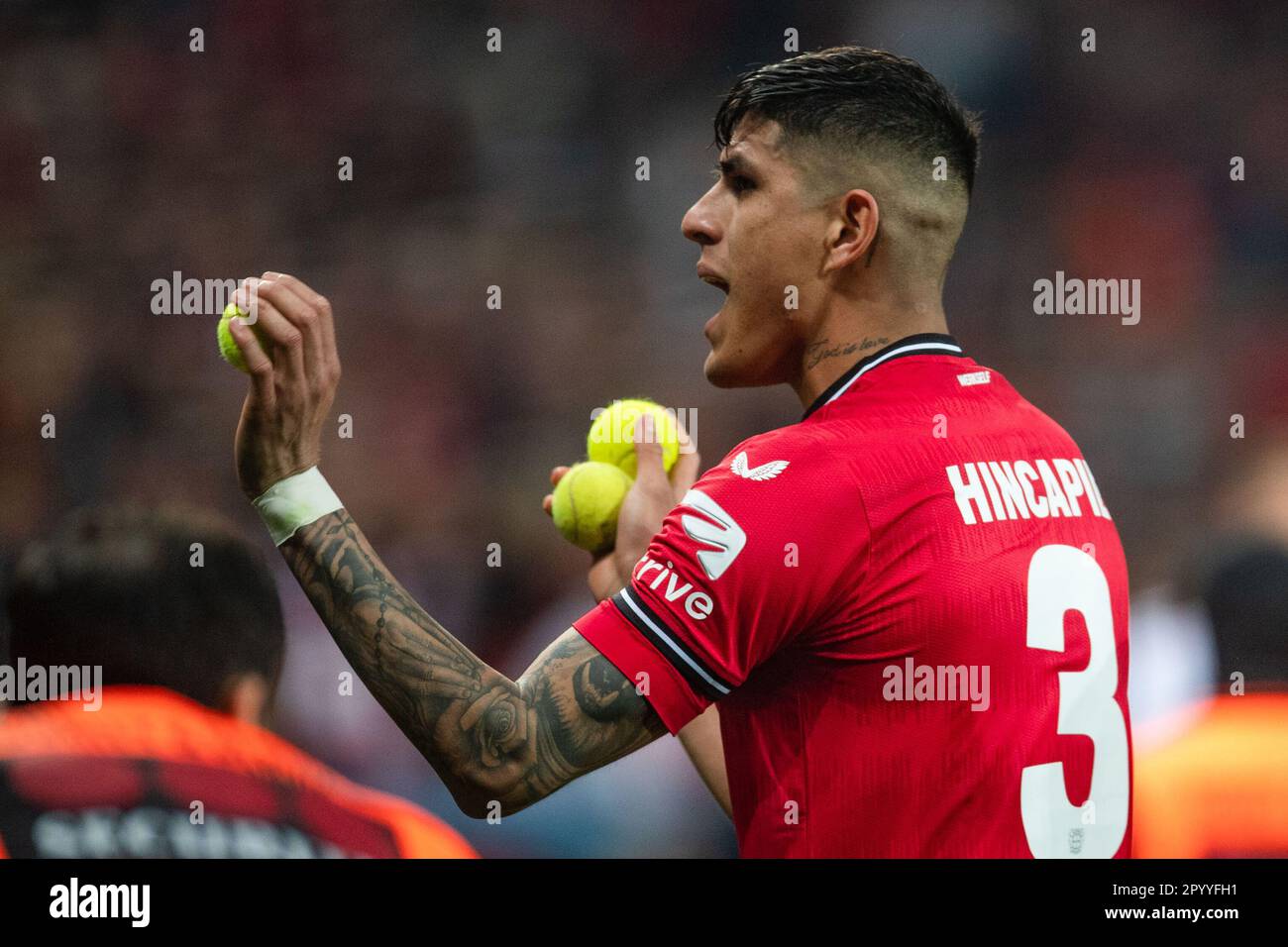 Leverkusen, Deutschland. 05. Mai 2023. Fußball: Bundesliga, Bayer Leverkusen - 1. FC Köln, Spieltag 31, BayArena. Die Piero Hincapie von Leverkusen sammelt Tennisbälle, die Köln-Fans auf den Platz geworfen haben. Kredit: Marius Becker/dpa - WICHTIGER HINWEIS: Gemäß den Anforderungen der DFL Deutsche Fußball Liga und des DFB Deutscher Fußball-Bund ist es verboten, im Stadion aufgenommene Fotos und/oder das Spiel in Form von Sequenzbildern und/oder videoähnlichen Fotoserien zu verwenden oder verwenden zu lassen./dpa/Alamy Live News Stockfoto