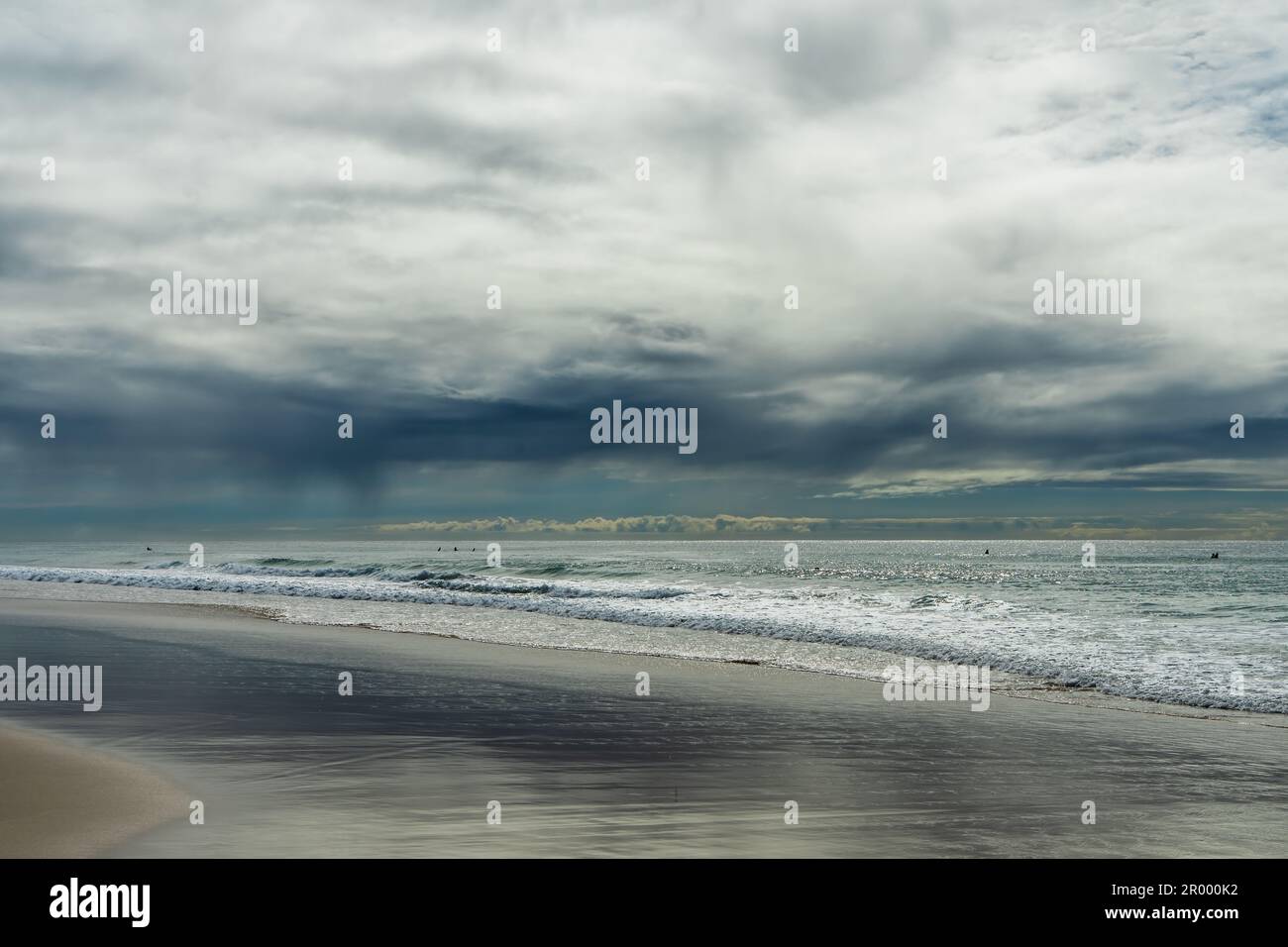 Tief über dem Meer hängende Regenwolken an einem Herbsttag am Currumbin Beach, Queensland, Australien. Stockfoto