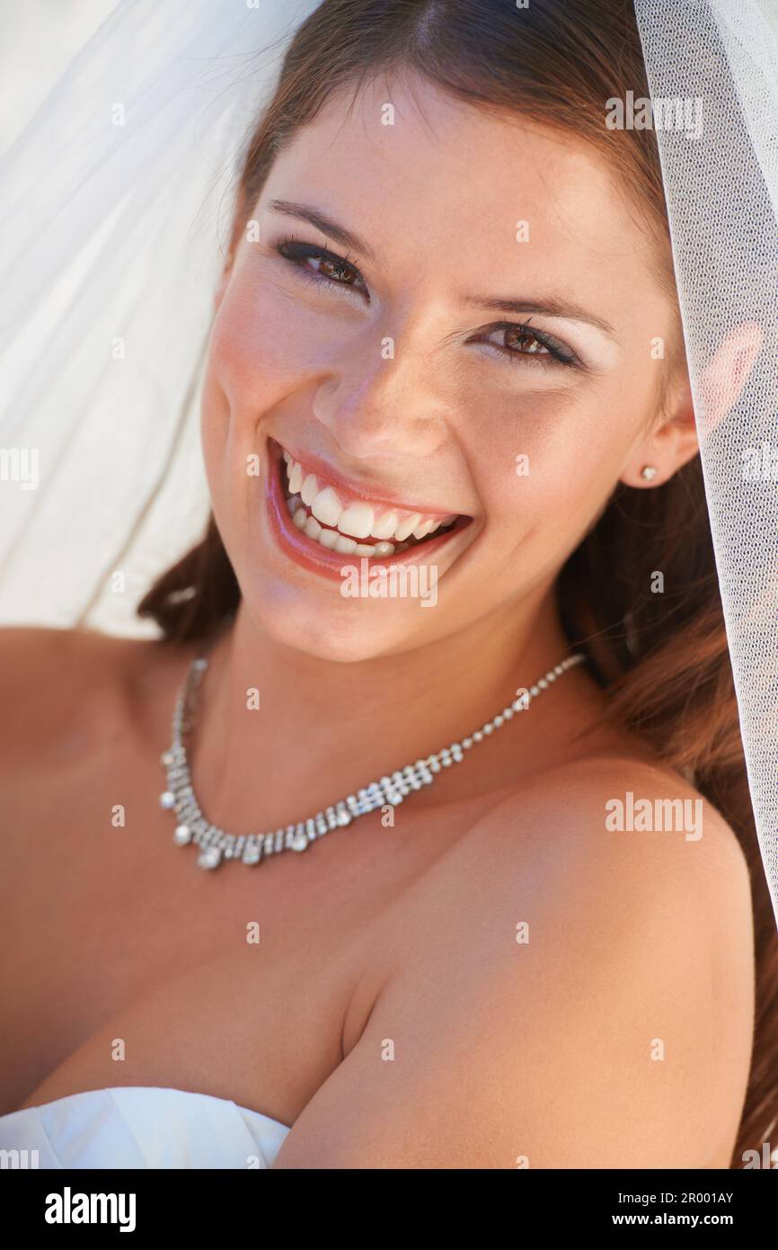 Die errötende Braut. Nahaufnahme Porträt einer wunderschönen jungen Braut, die dich glücklich anlächelt. Stockfoto