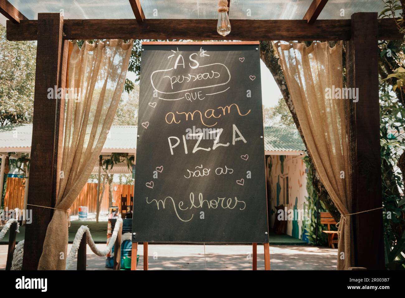Unterschreiben Sie mit der Botschaft auf Portugiesisch - Leute, die Pizza lieben, sind die Besten. Stockfoto