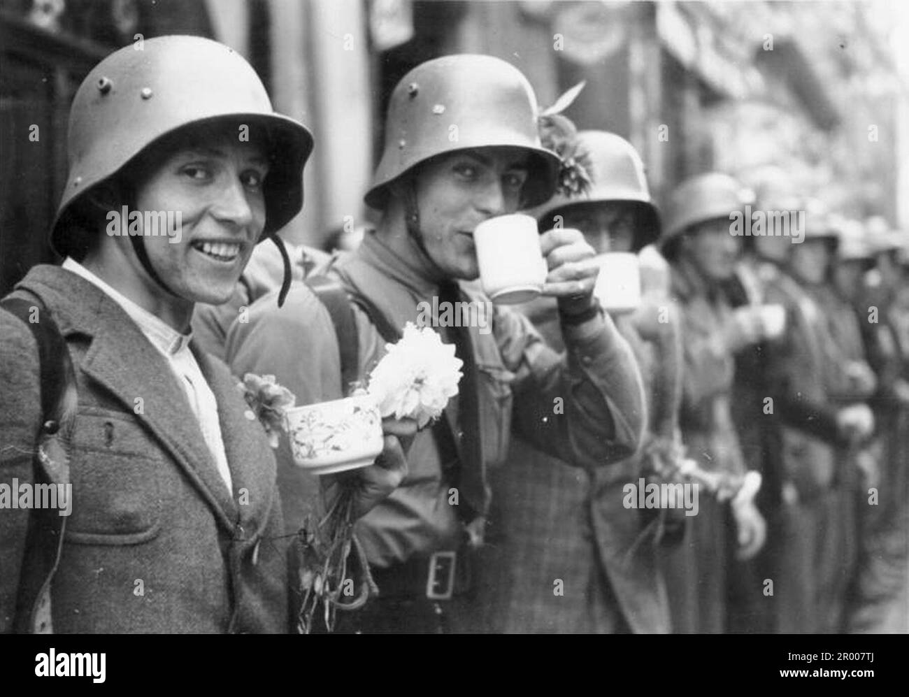 Freiwillige des Freien Korps Sudetens erhalten Erfrischungen von der örtlichen Bevölkerung in der Stadt Eger/Cheb während der Annexion des Sudetlands. Nach der Annexion Österreichs verlangte Hitler, dass er in die Region Sudeten der Tschechoslowakei aufgenommen wird. Auf der Münchner Konferenz im September 1938 stimmten die westlichen Mächte dem zu, und die nazis besetzten das Gebiet. Kurz nachdem Hitler sein Versprechen gebrochen hatte und in den Rest der Tschechoslowakei einmarschierte, widmete er sich Polen. Bundesarchiv, Bild 146-1986-042-14/CC-BY-SA 3,0 Stockfoto