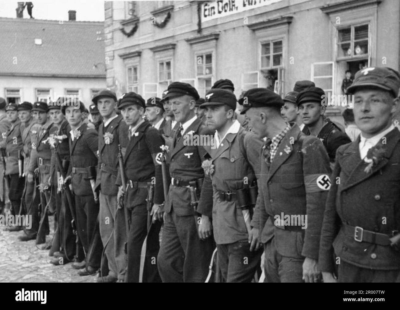 Mitglieder des Sudetendeutschen Volontären Korps sind bereit, Hitler nach seiner Ankunft in Niemes nach der Annexion des Sudetenlands zu begrüßen. Nach der Annexion Österreichs verlangte Hitler, dass er in die Region Sudeten der Tschechoslowakei aufgenommen wird. Auf der Münchner Konferenz im September 1938 stimmten die westlichen Mächte dem zu, und die nazis besetzten das Gebiet. Kurz nachdem Hitler sein Versprechen gebrochen hatte und in den Rest der Tschechoslowakei einmarschierte, widmete er sich Polen. Bundesarchiv, Bild 146-1972-026-51/CC-BY-SA 3,0 Stockfoto
