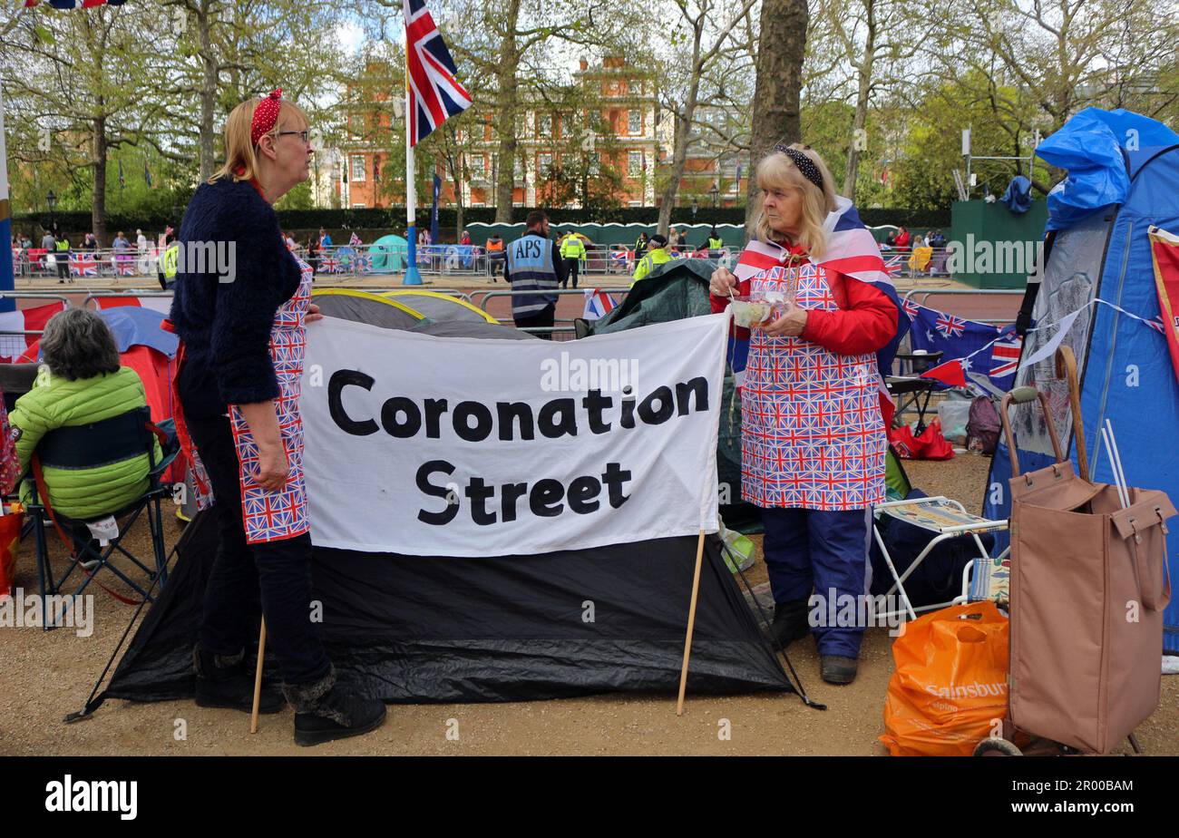 Während der Krönung des Königs in London haben sich einige Leute möglicherweise in der Mall aufgehalten und sich verkleidet, während sie ein Schild mit der Aufschrift „Coronation Street“ hielten, auf dem die beliebte britische Seifenoper steht. Stockfoto