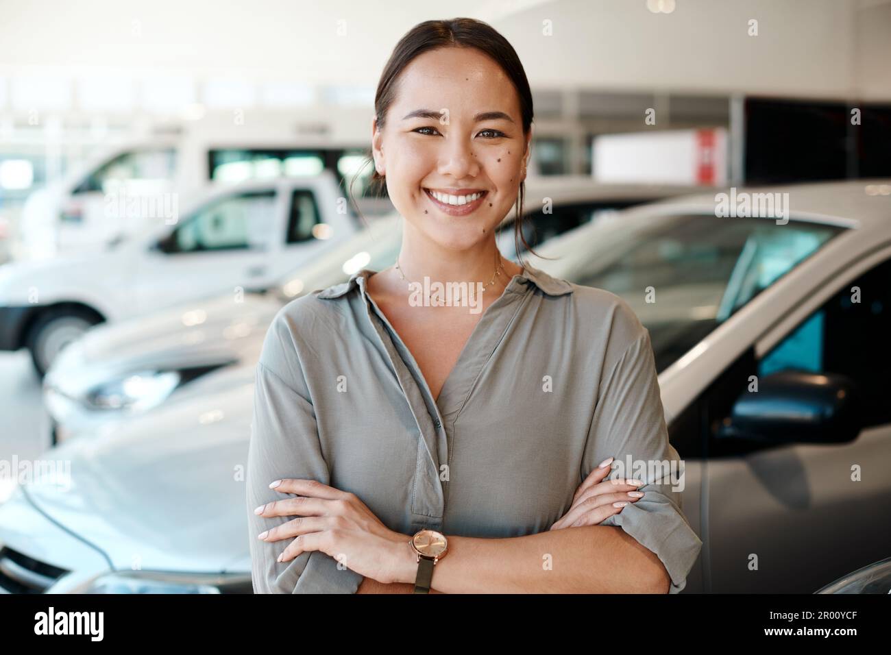 Du wirst mich hören, bevor du mich siehst. Eine junge Frau, die neben dem Auto steht, will sie kaufen. Stockfoto