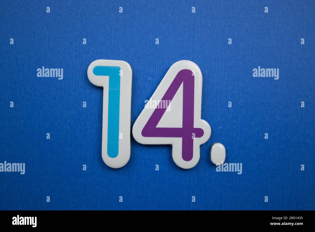 Die Nummer 14, auf blauem Hintergrund, von oben fotografiert, hellblau und lila in Farbe. Stockfoto