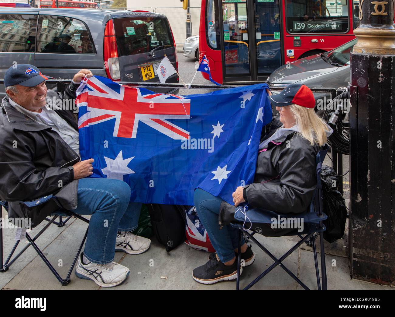 Australische Wunschfreunde mit australischer Flagge, die vor der Krönung von König Karl III. Vor dem Trafalgar Square in London auf den Campinghockern saßen Stockfoto