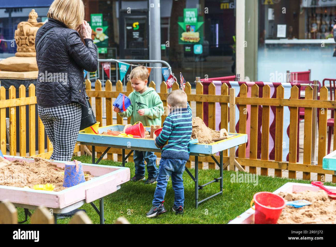 Rumpf, East Riding of Yorkshire. Mai 2023. Hull City Centre feierte heute die Krönung von König Charles stilvoll, die Stadt ist eine Waschung in Rot, weiß und Blau. Die Veranstaltungen fanden auf dem Queen Victoria Square, der King Edward St und dem Beverley Gate statt, wobei die Krönung auf großen Leinwänden im Stadtzentrum gezeigt wurde. IM BILD: Archie (LT) und Joe (rt) beide 4 Jahre alt, spielen mit dem Sand. BridgetCatterall/AlamyLiveNews Stockfoto