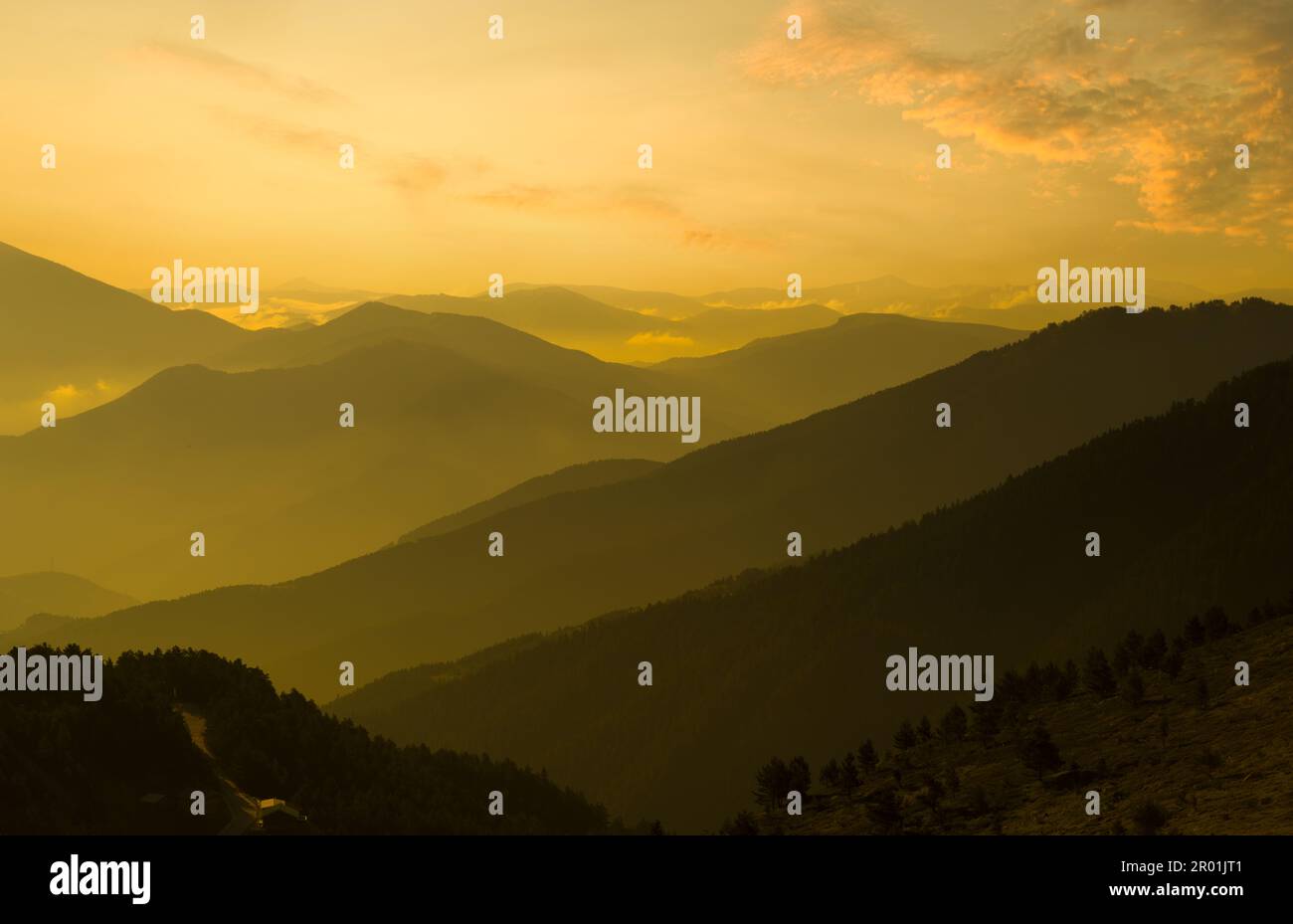 Orange Sonnenuntergang im Hochland. Nebliger Blick auf die Bergkette. Naturhintergrund Stockfoto