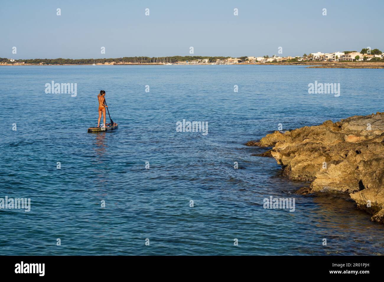 Einsame Frau übt Paddle-Surfen im Mittelmeer, Sa Rapita, Campos, Mallorca, Balearen, Spanien. Stockfoto