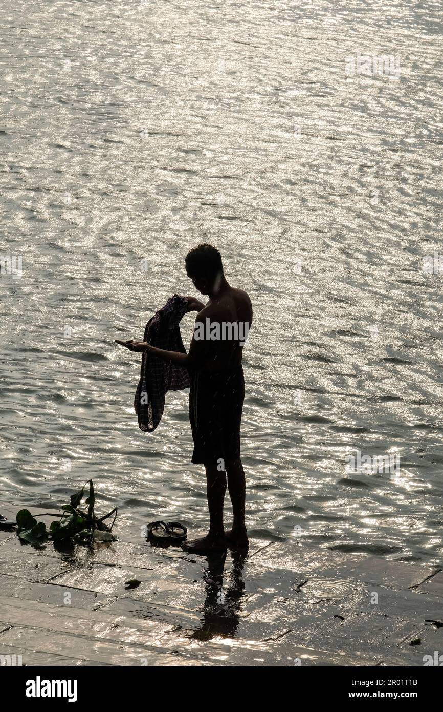 Ein Mann, der während des Sonnenuntergangs ein Bad am Ghat des heiligen Flusses Ganga in Nord-Kalkutta nahm. (Foto: Dipayan Bose / SOPA Images / Sipa USA) Stockfoto