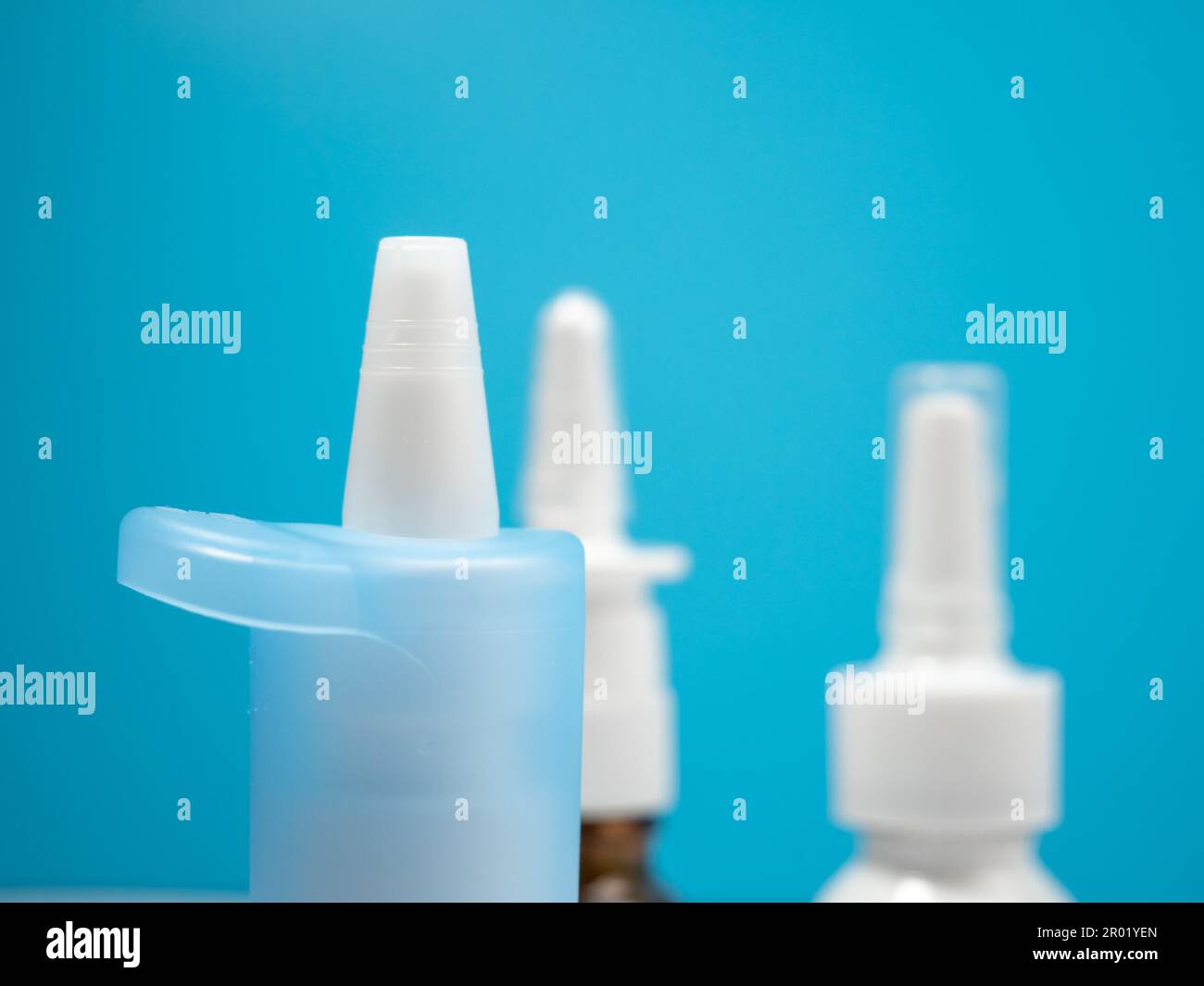 Nasenspray-Flaschen auf blauem Hintergrund, Behandlung einer Erkältung mit Nasenspray. Medizin-Nahaufnahme. Stockfoto