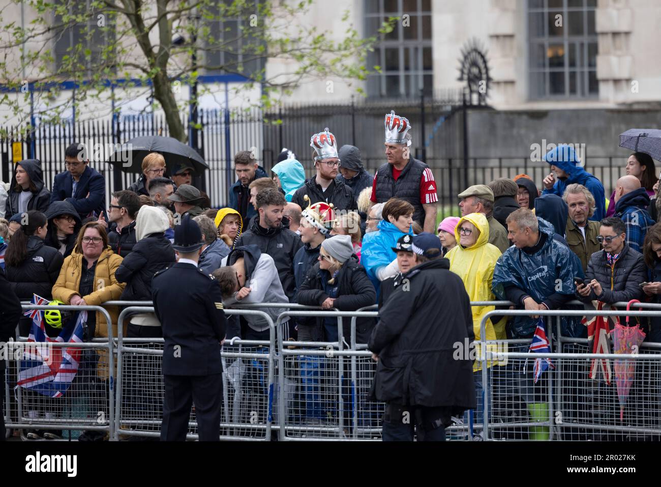 Königliche Fans warten im Regen darauf, dass König Charles auf seinem Weg zur Krönung in Westminster Abbey durch Whitehall fährt. Karl trat am 8. September 2022 auf den Thron, nach dem Tod seiner Mutter, ihrer verstorbenen Königin Elizabeth II. Die Krönung von König Karl III. Findet etwa 6 Monate später am 6. Mai 2023 statt. Stockfoto