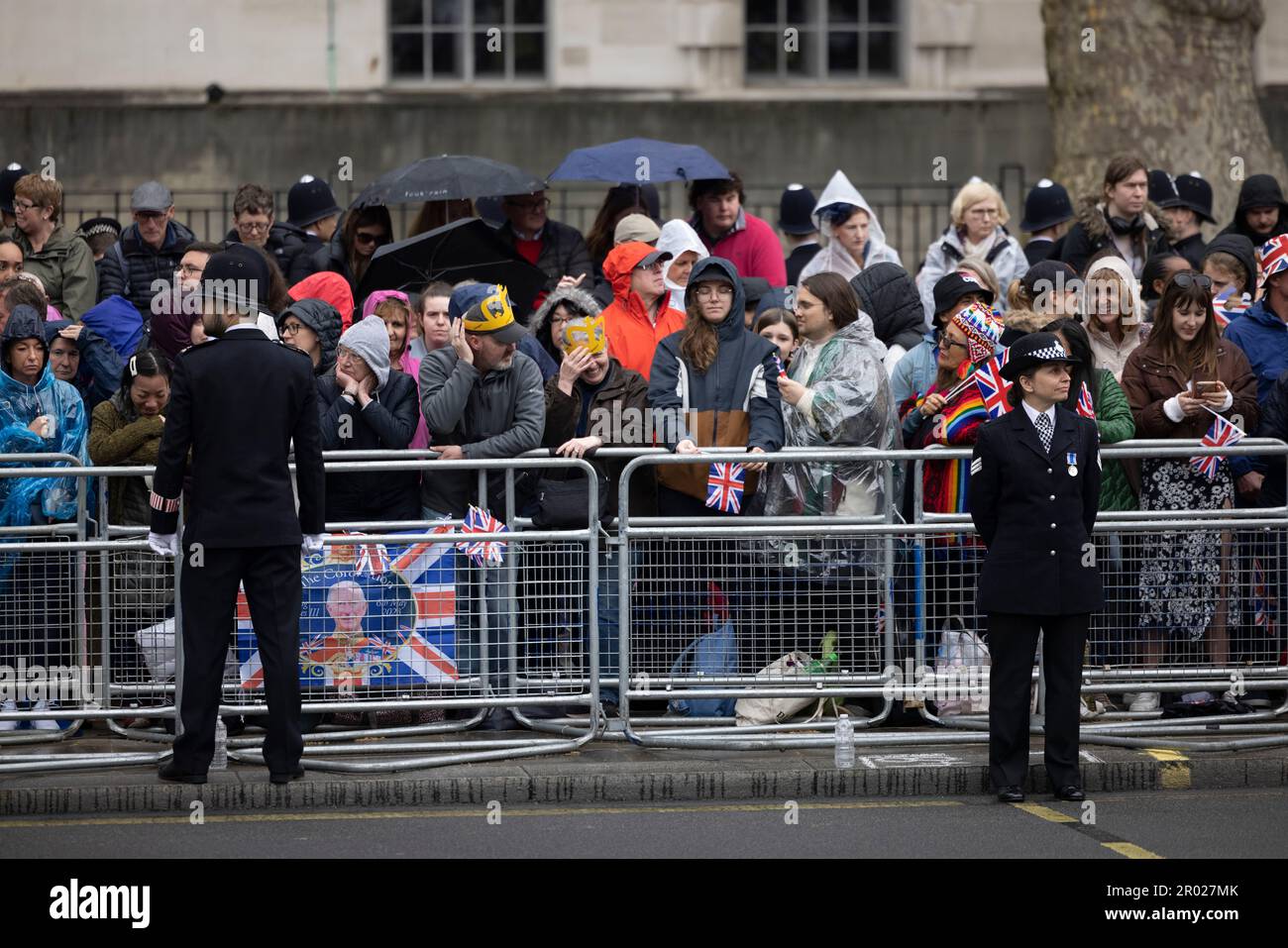 Königliche Fans warten im Regen darauf, dass König Charles auf seinem Weg zur Krönung in Westminster Abbey durch Whitehall fährt. Karl trat am 8. September 2022 auf den Thron, nach dem Tod seiner Mutter, ihrer verstorbenen Königin Elizabeth II. Die Krönung von König Karl III. Findet etwa 6 Monate später am 6. Mai 2023 statt. Stockfoto